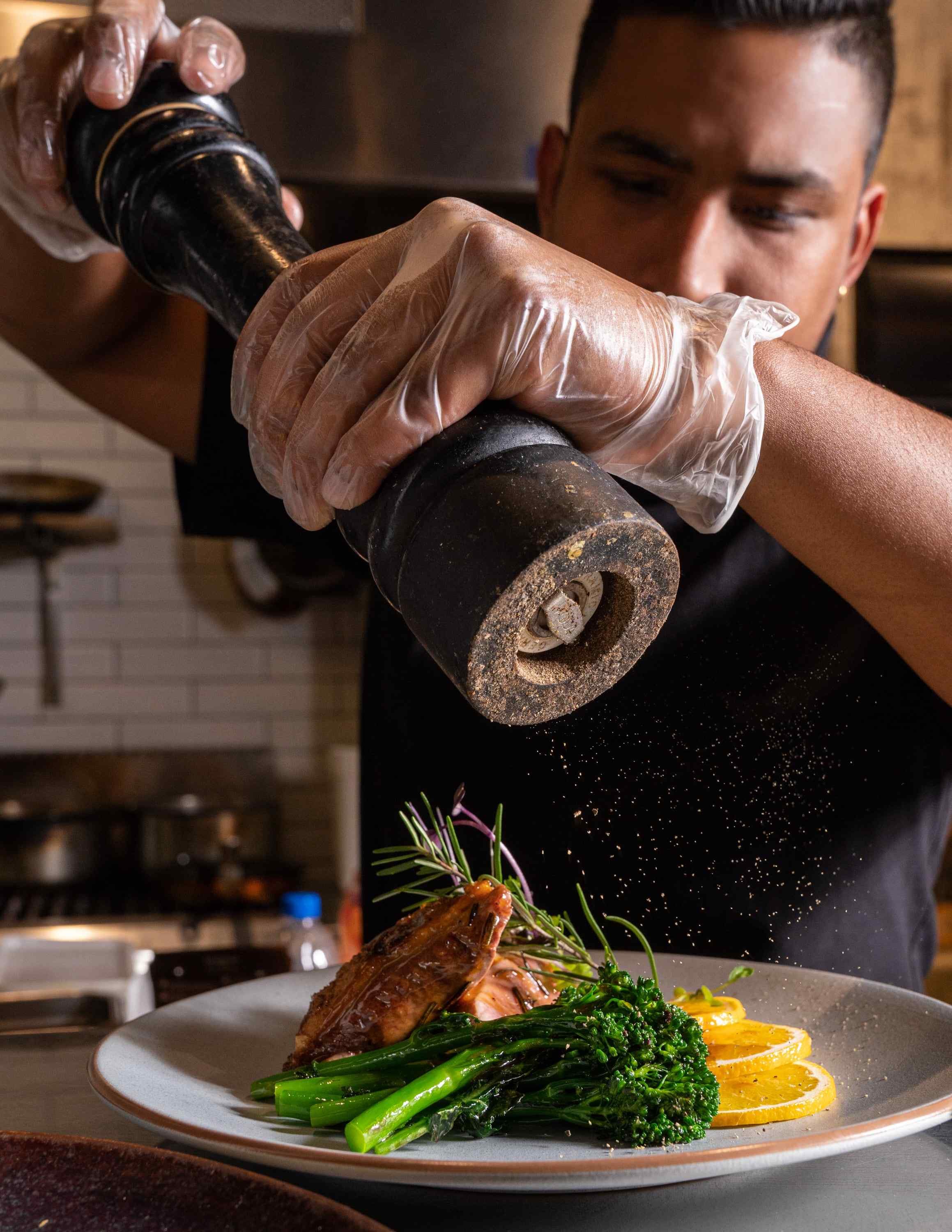  Fresh black pepper being cracked over duck l’orange 