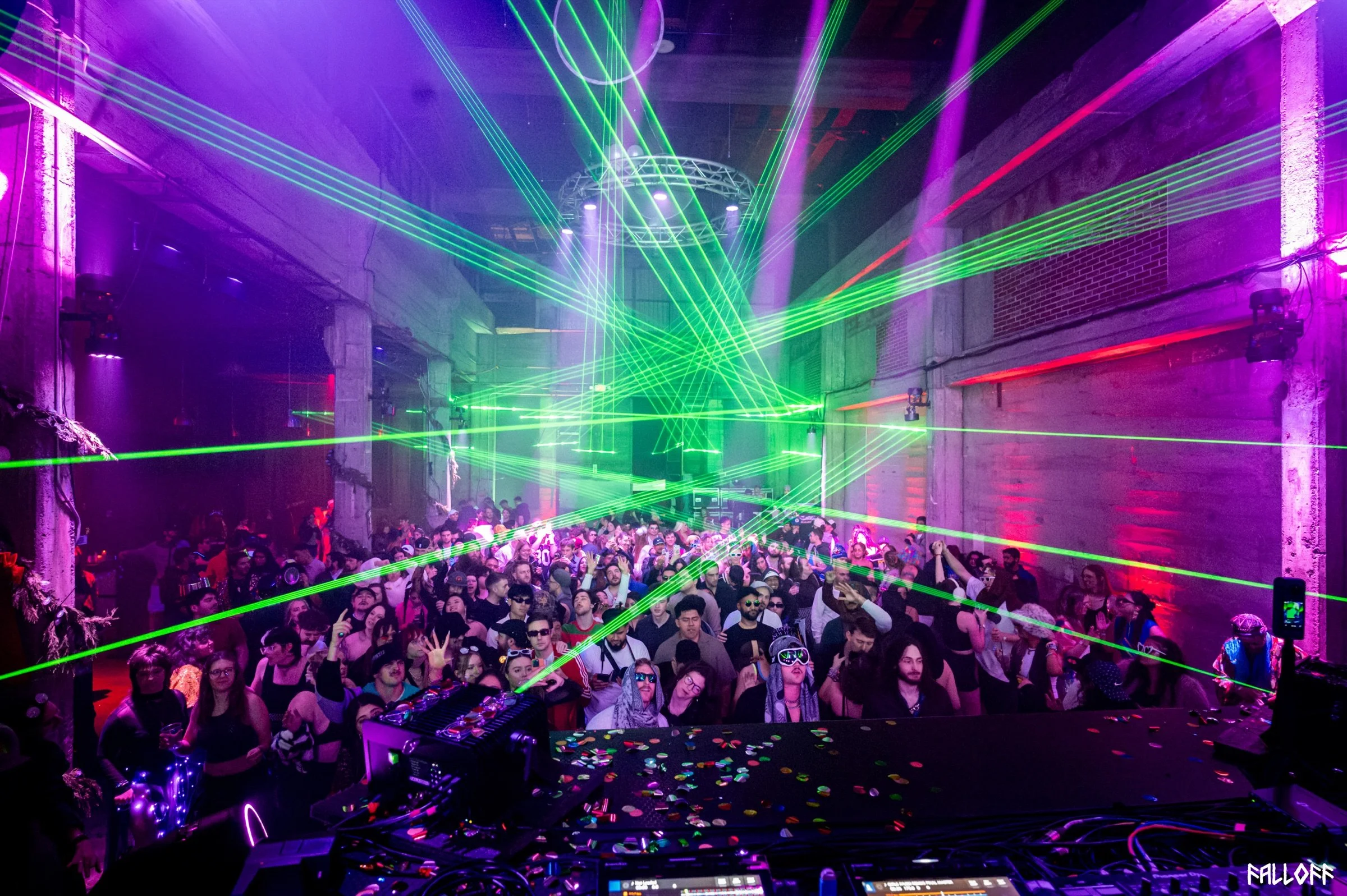 Dance-floor crowd and lasers viewed from the DJ booth — photo by Falloff Pix Media