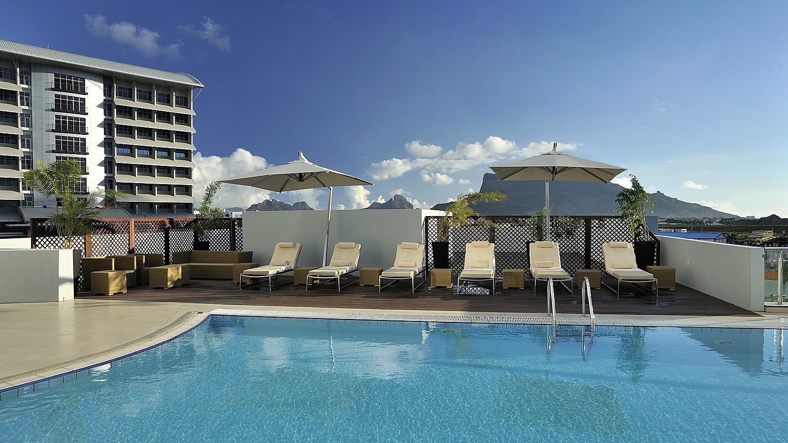 Completed rooftop swimming pool and terrace with views across the Ebene and Moka landscape.
