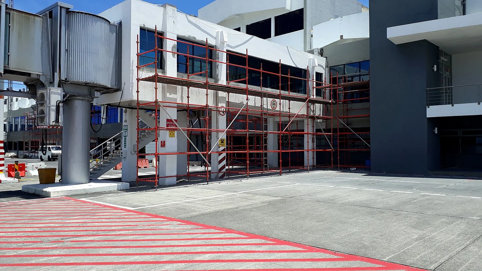Airside facade refurbishment in progress, including glazing, cladding, scaffolding and adjacent operational interfaces.