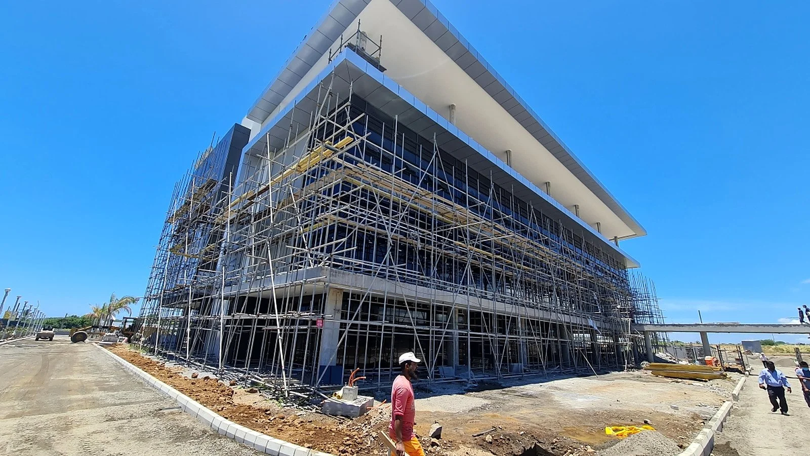 Close construction-stage view of the main ICCC building, including facade installation, scaffolding and external works.
