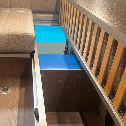 Bed frame in rear lounge opened showing access to storage space in lounge and access to rear garage space.