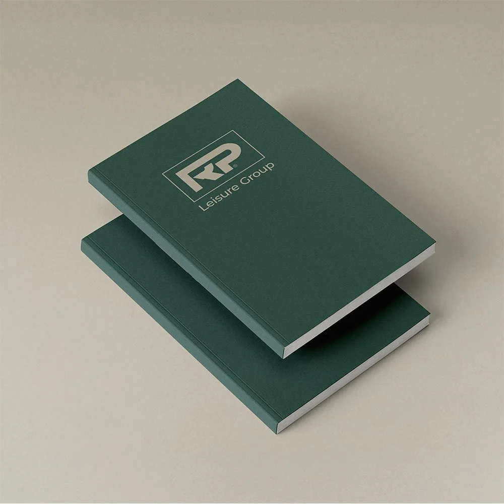 Two green booklets with a logo and the words "Leisure Group" on the cover, placed on a beige surface.