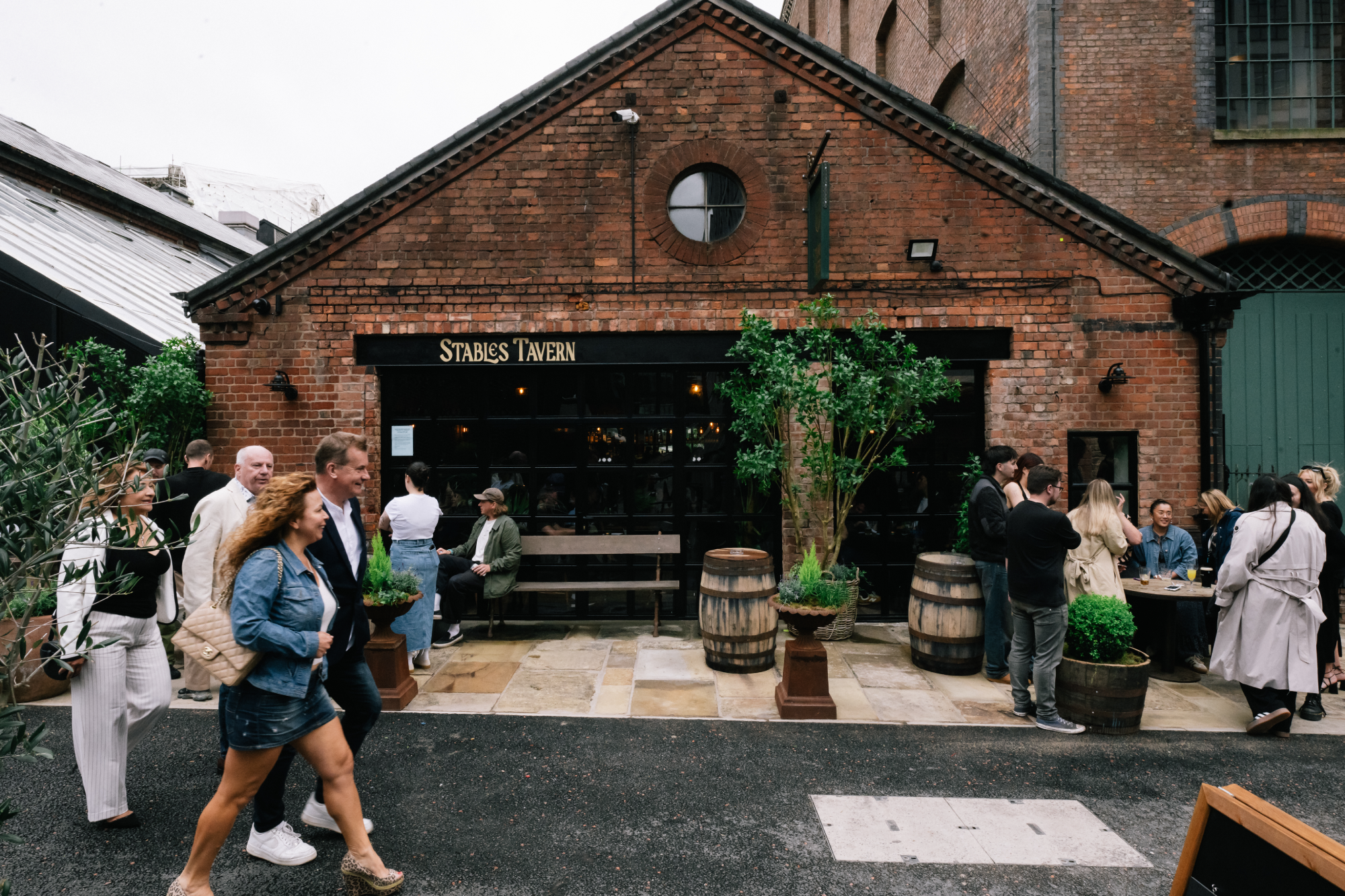 People drinking in the outside seating area of Stables Tavern in Spinningfields.