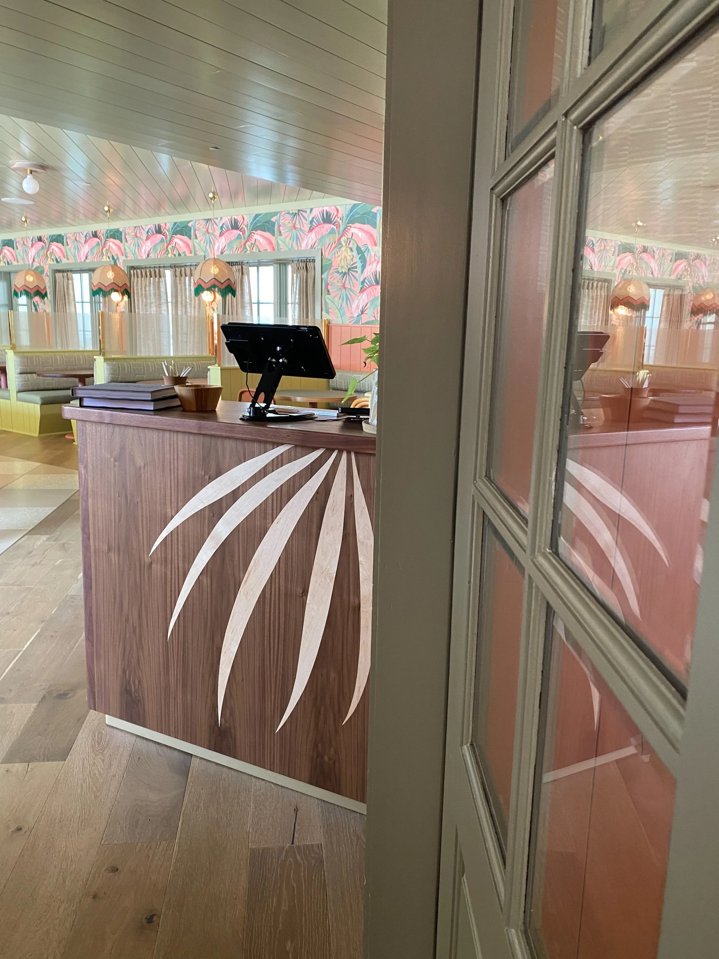 The collaborative relationship ran both ways and continued evolving — the entrance to Little Palm was subsequently designed to echo Pure Hart's palm frond treatment, completing a design conversation between mural and architecture.