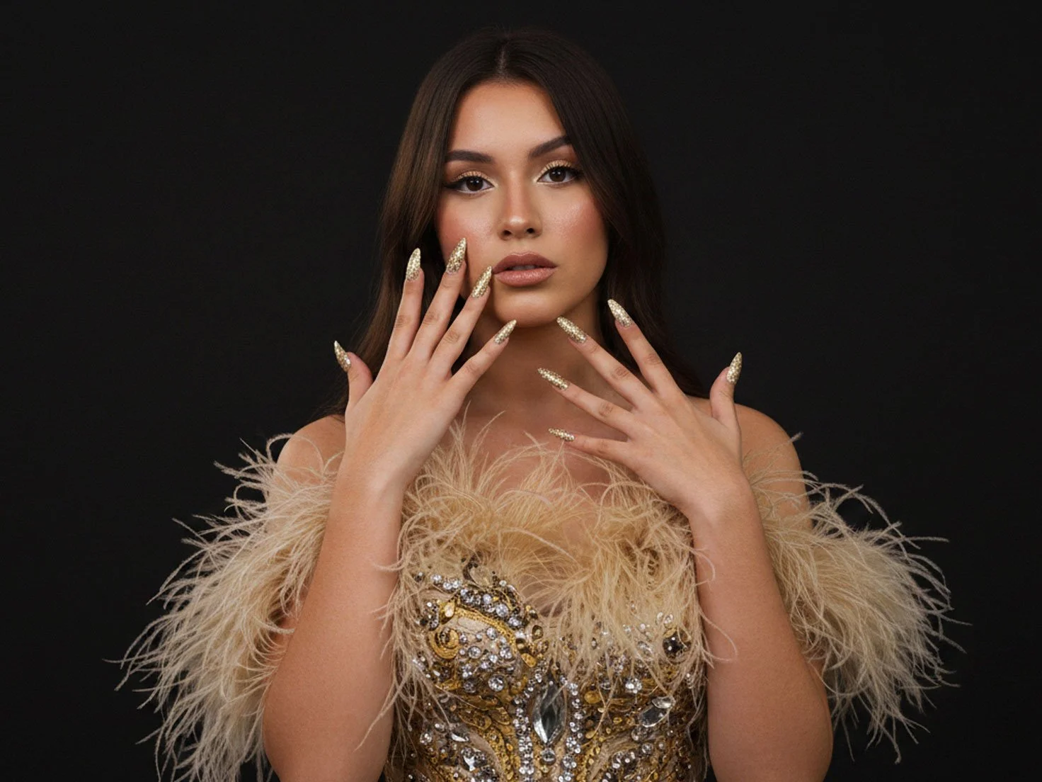 A Hispanic teenager wearing a glamorous dress and showcasing gold design of Gel X nails.