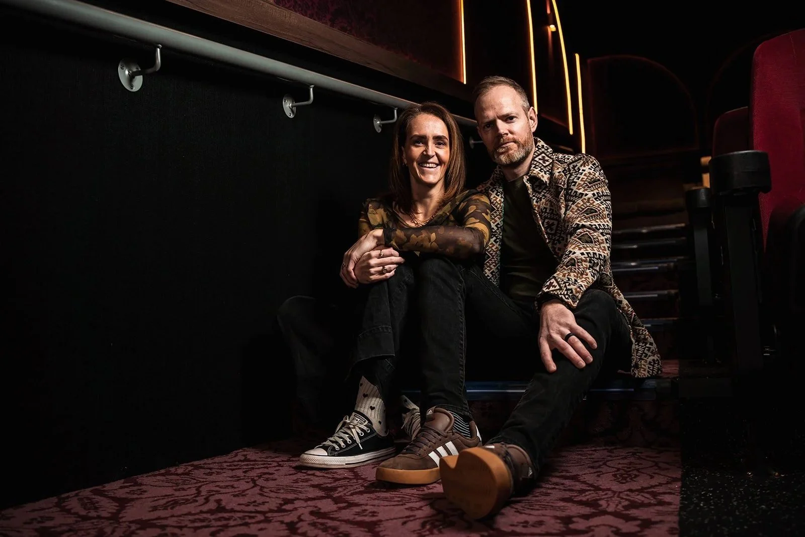 Tash and Tony sitting on the stairs of a cinema