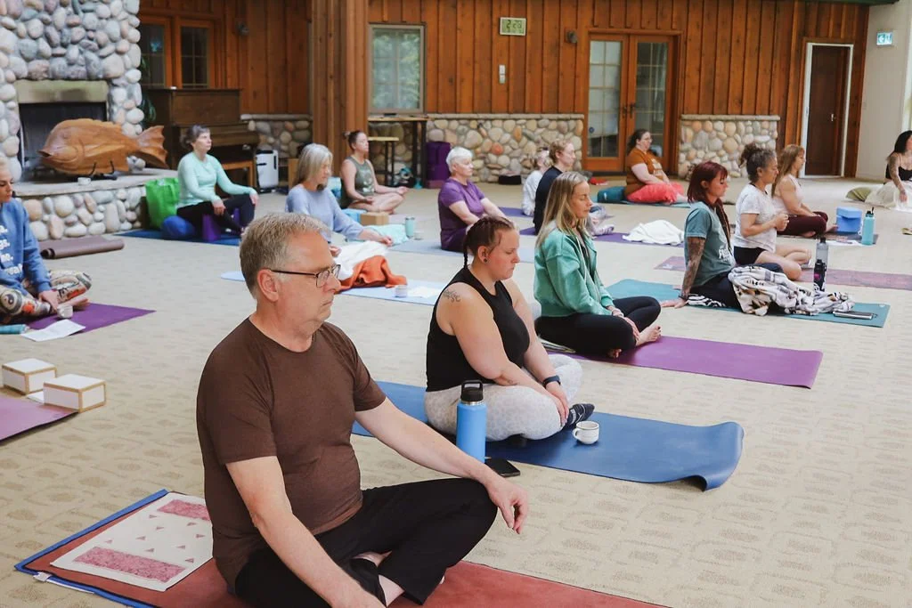 A group participating in a cacao ceremony and meditating at a yoga retreat.