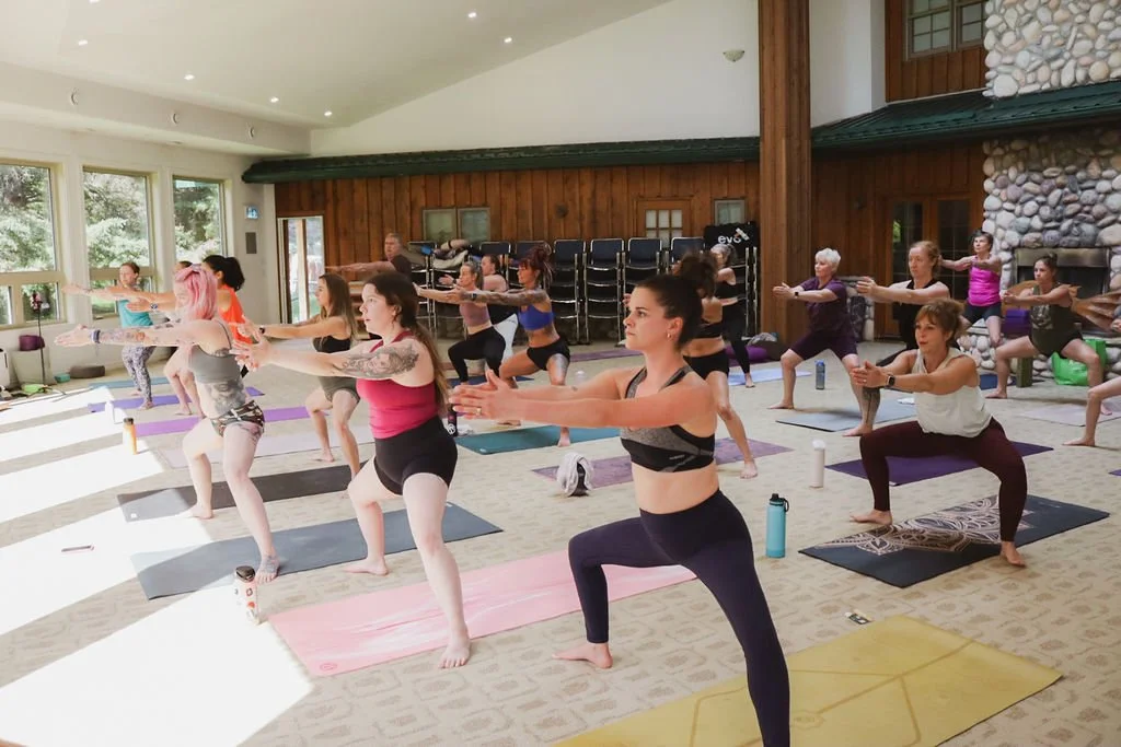 A group in an open room doing yoga at a yoga retreat in Alberta.