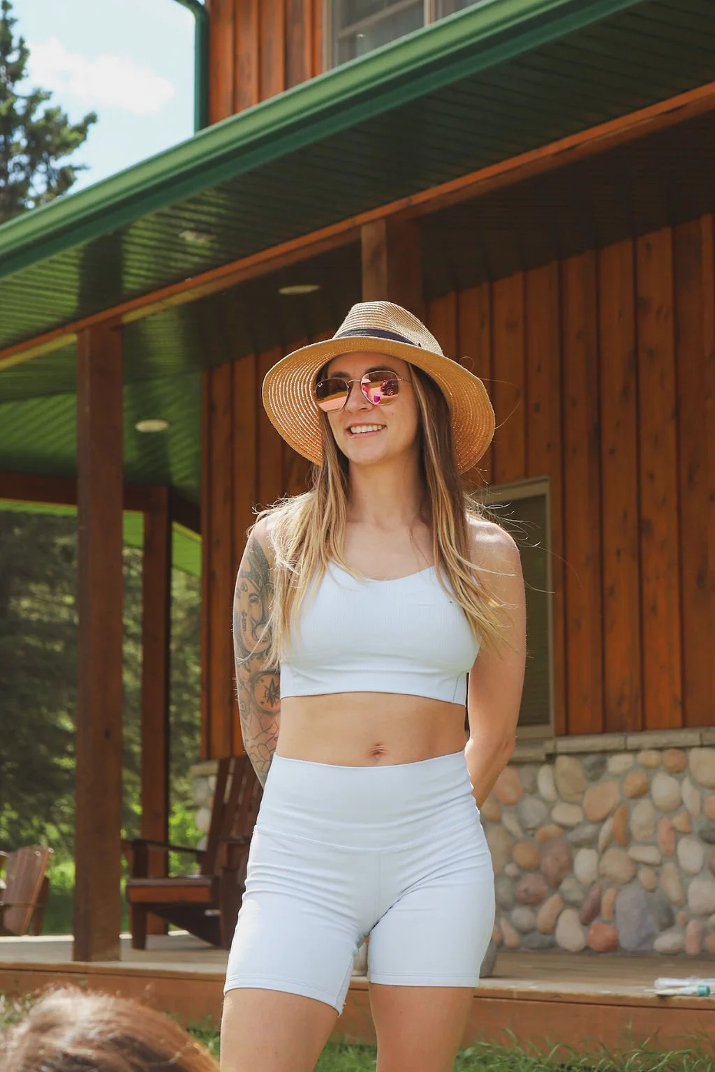 woman standing outside on a beautiful day with blue sports wear on.