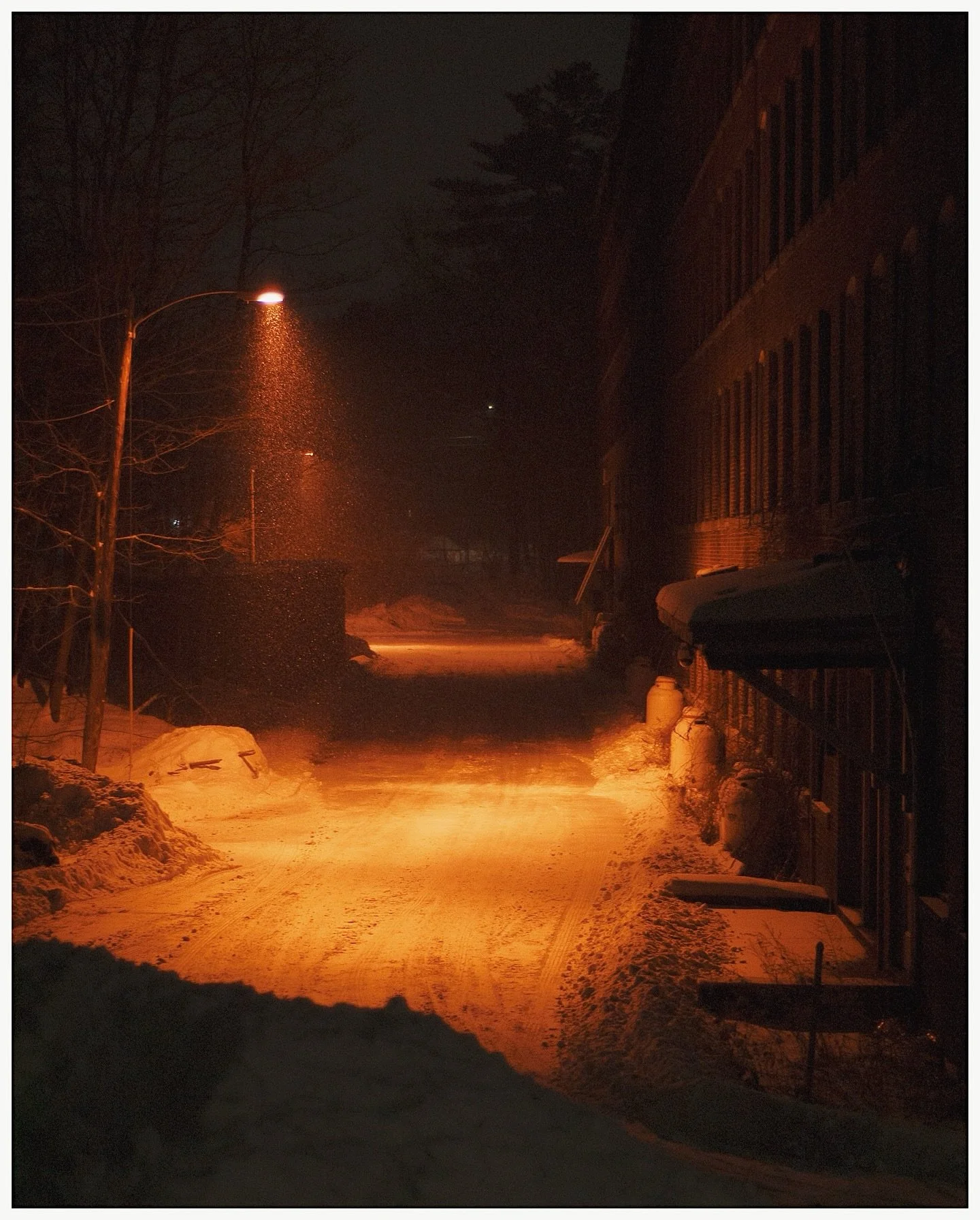 warm tones on a cold, snowy night
I&rsquo;ve been wanting to get a shot of this old factory driveway at night for a while and figured the snowstorm we had last weekend would make the perfect setting. 

#nikond50 #minimalmag #moodytones #subjectivelyo