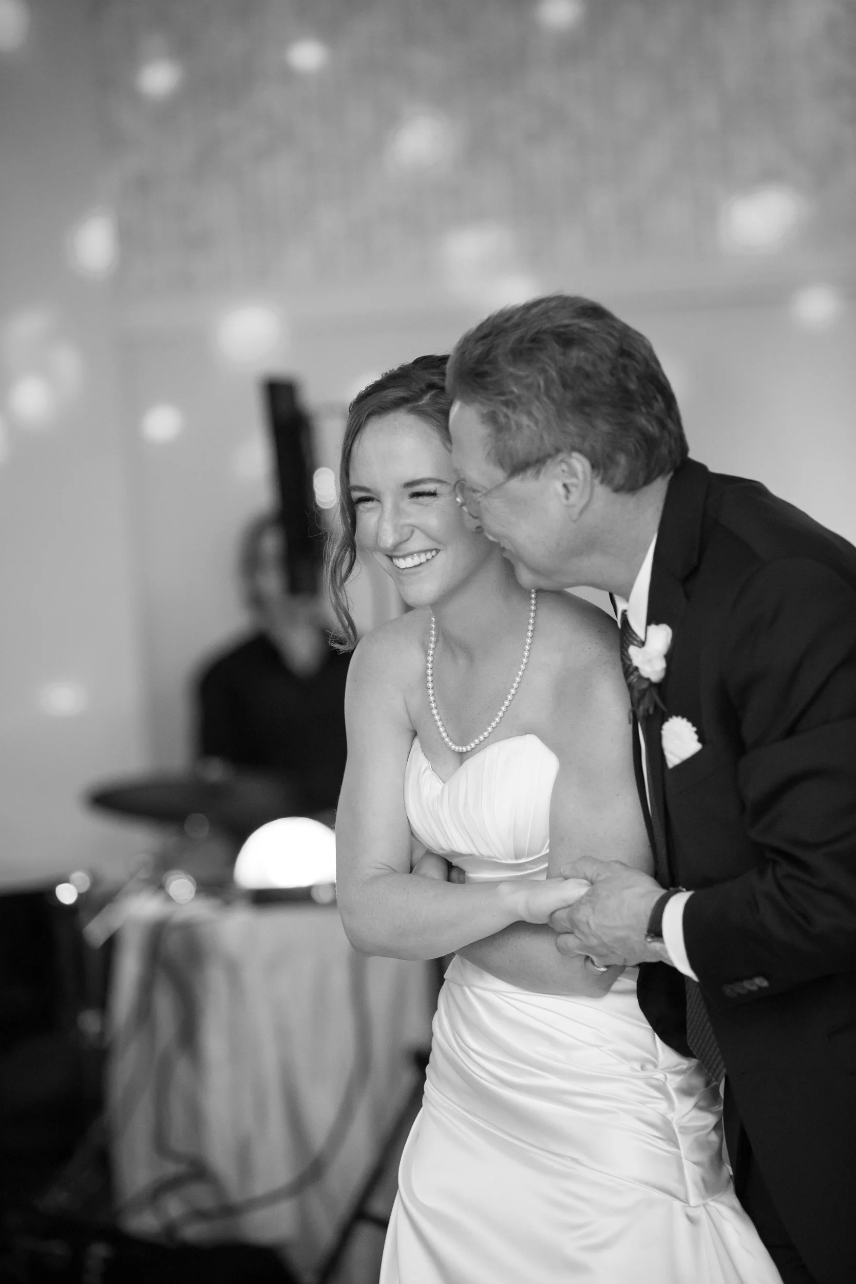 A father dancing with his daughter at her wedding.