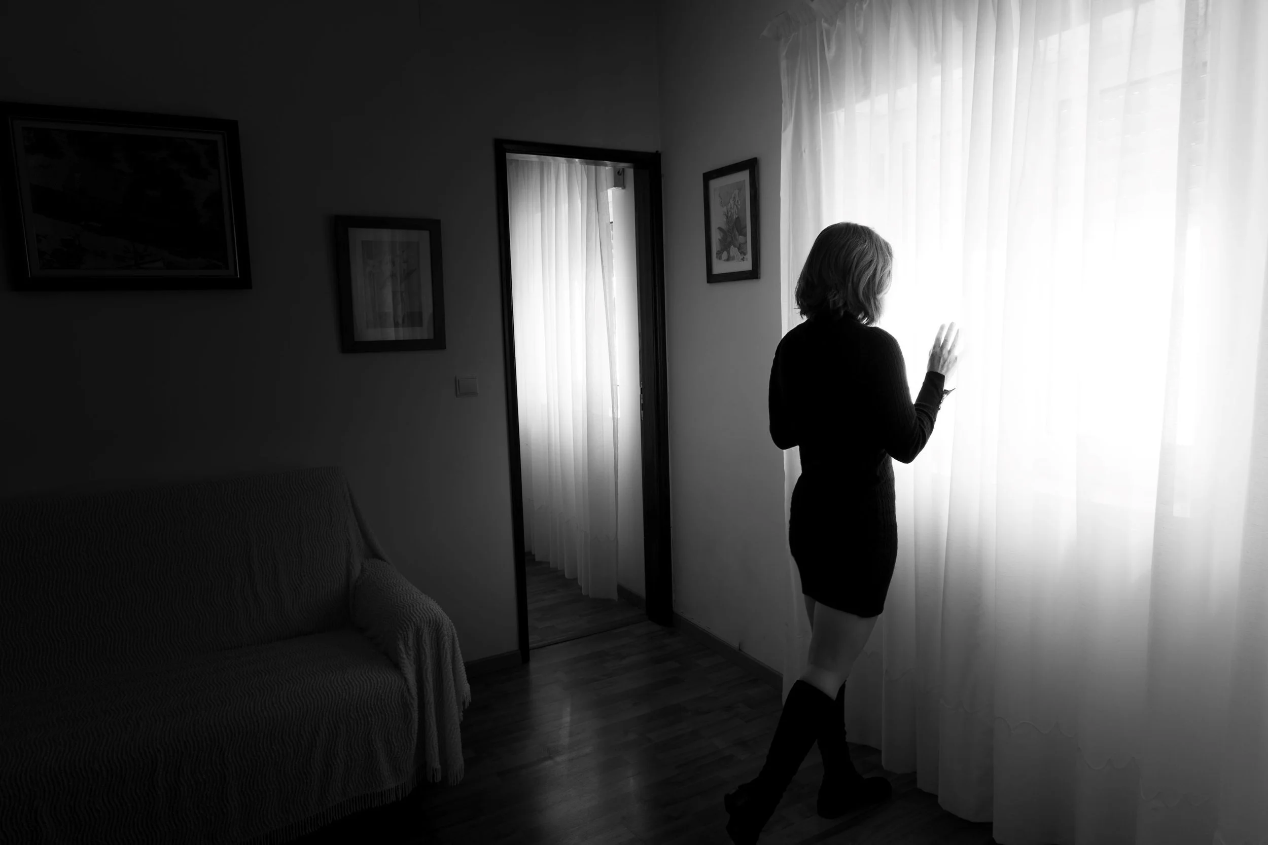 a woman standing behind a white curtain