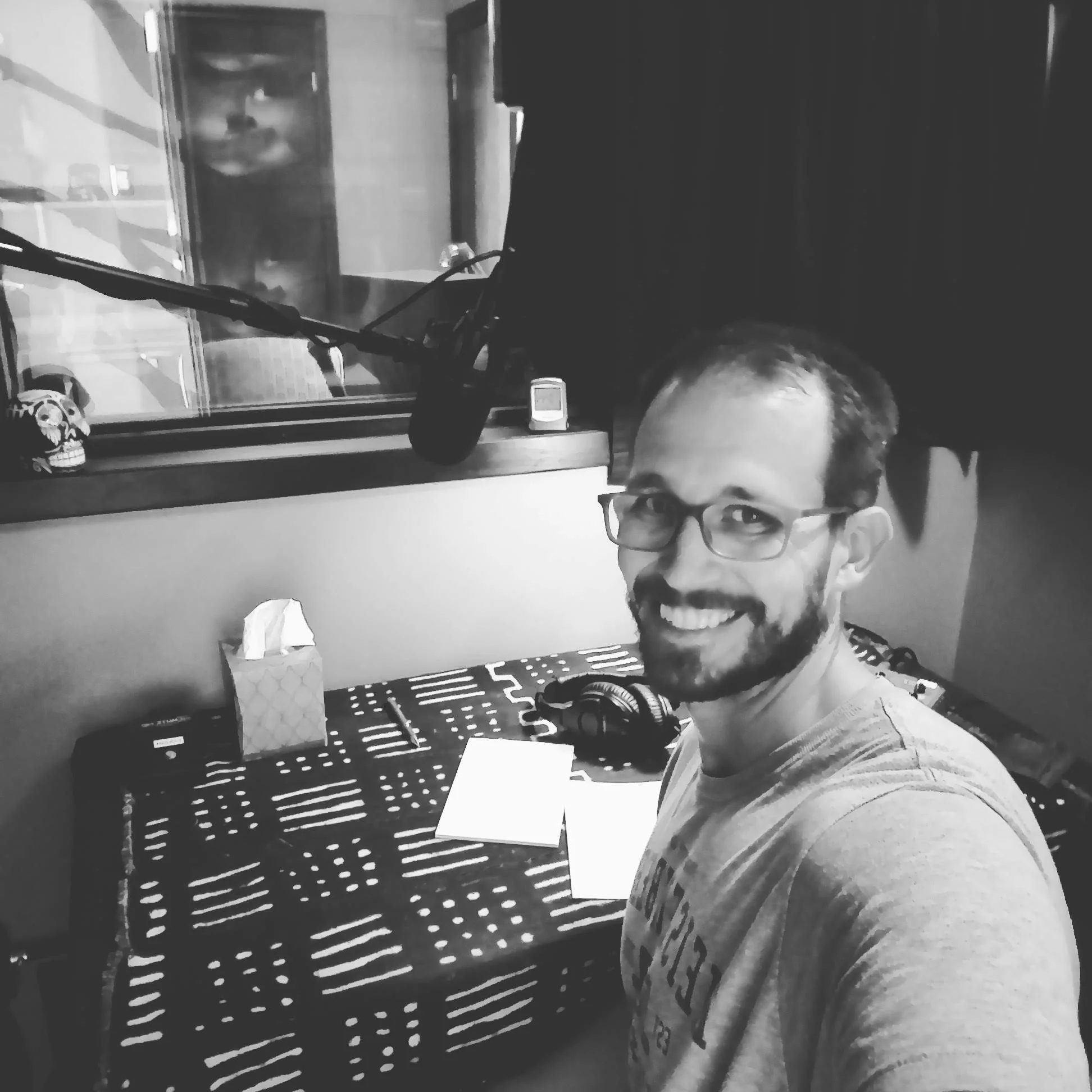 A smiling man at a radio station about discuss economic policy and unintended consequences.