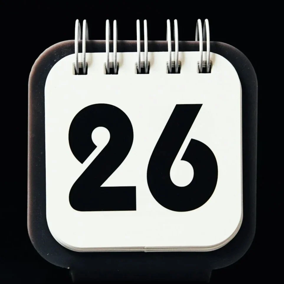 A close-up of a flip-style calendar showing the date 'September 26' with black numbers on a white background.