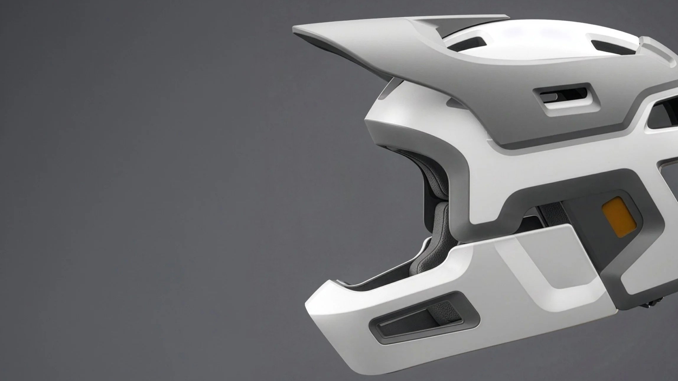 A close-up of a white and black futuristic helmet with a sleek design, resting against a gray background.