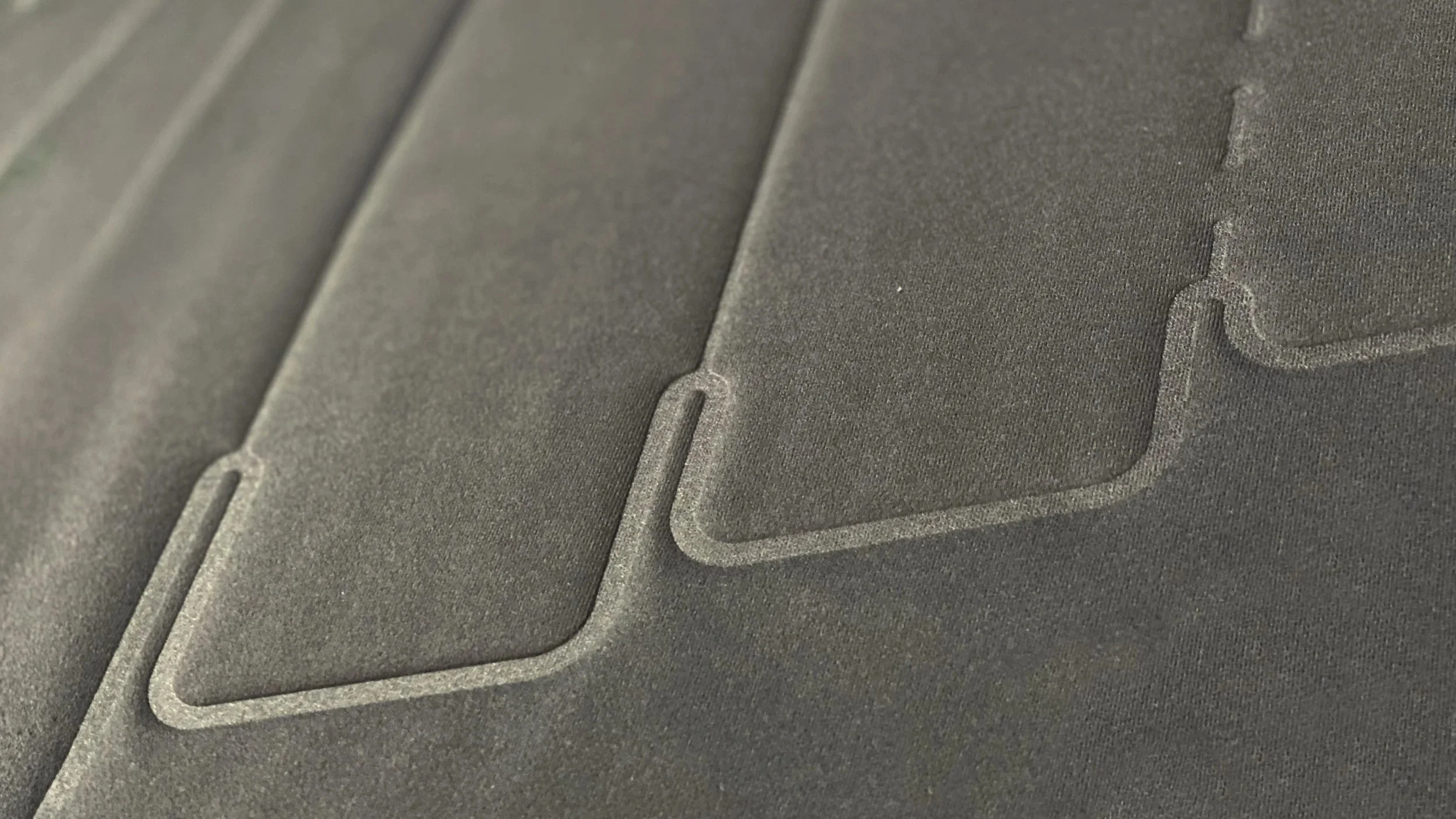 Close-up of textured gray surface with engraved bank card icons and chip outlines.