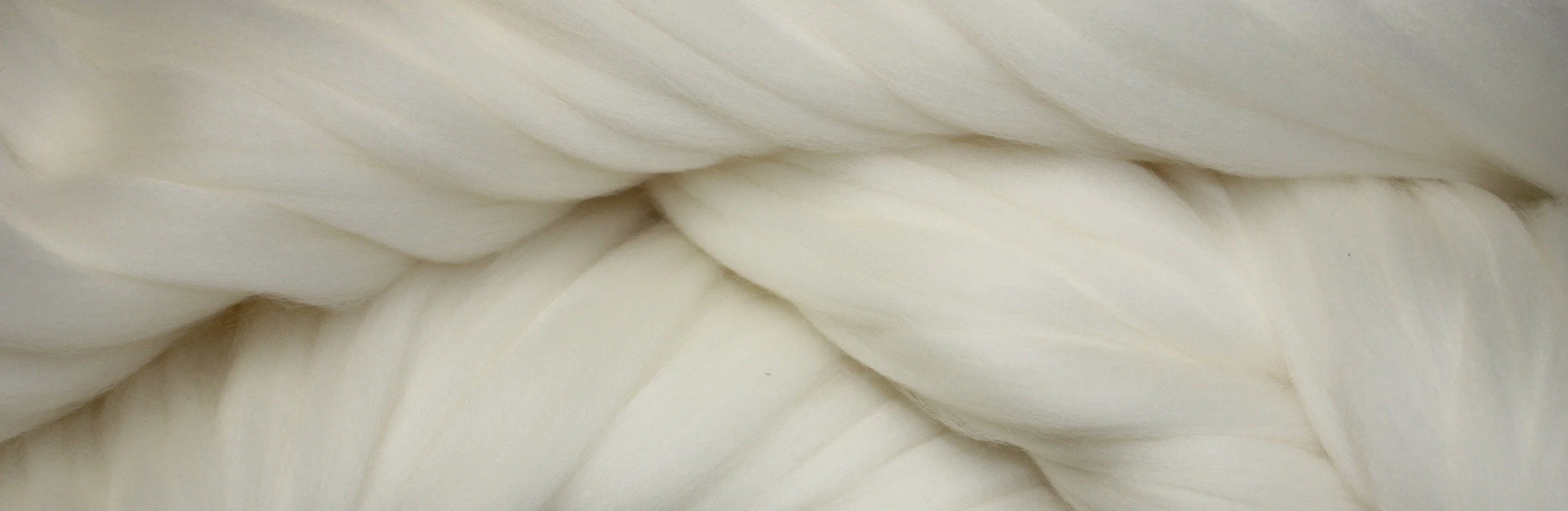 Close-up of large, white, woven fabric or material with soft, flowing texture.