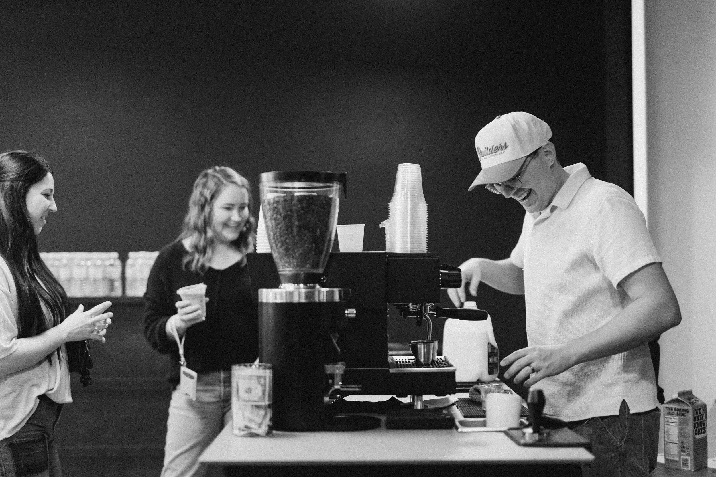 Person pouring steamed milk into a cup of coffee to make latte art.