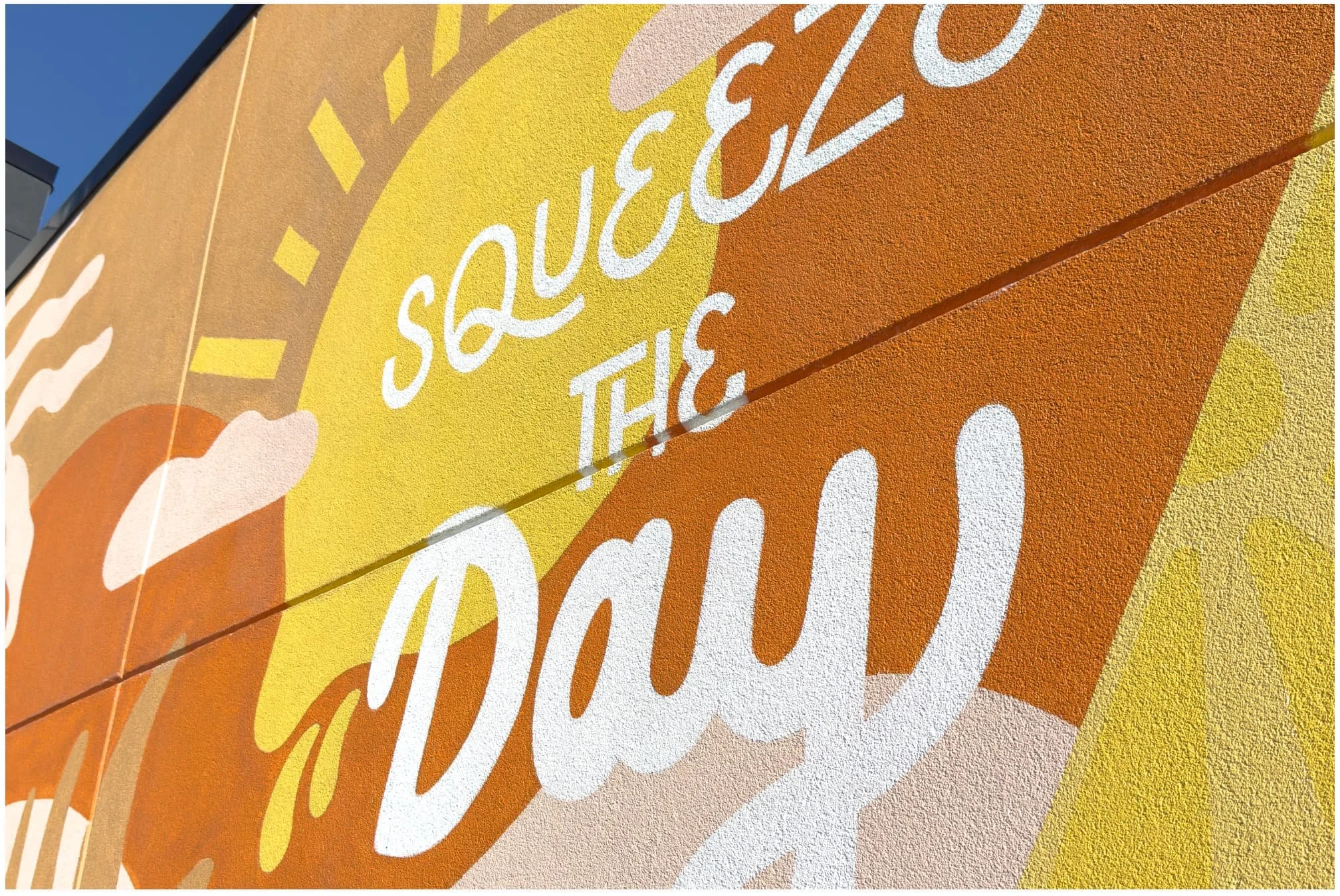 Sun and cloud detail from First Watch exterior mural — hand-painted by Juvy Torres