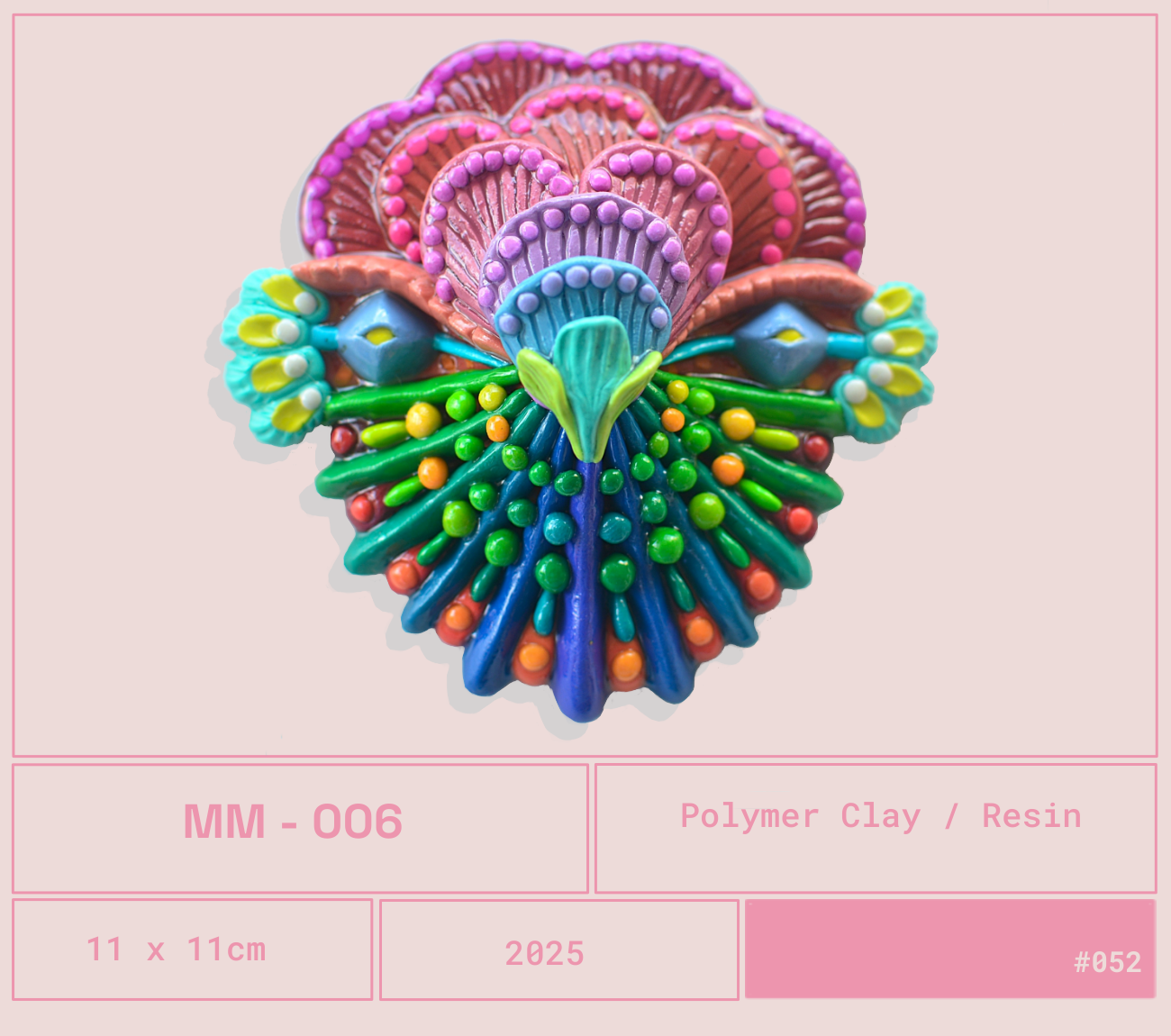 Imagen de un arte en resina de un diseño colorido con forma de corazón que parece un ave o mariposa, con detalles en tonos morados, azules, verdes, amarillos, naranjas y rojos. La composición es simétrica y decorativa.