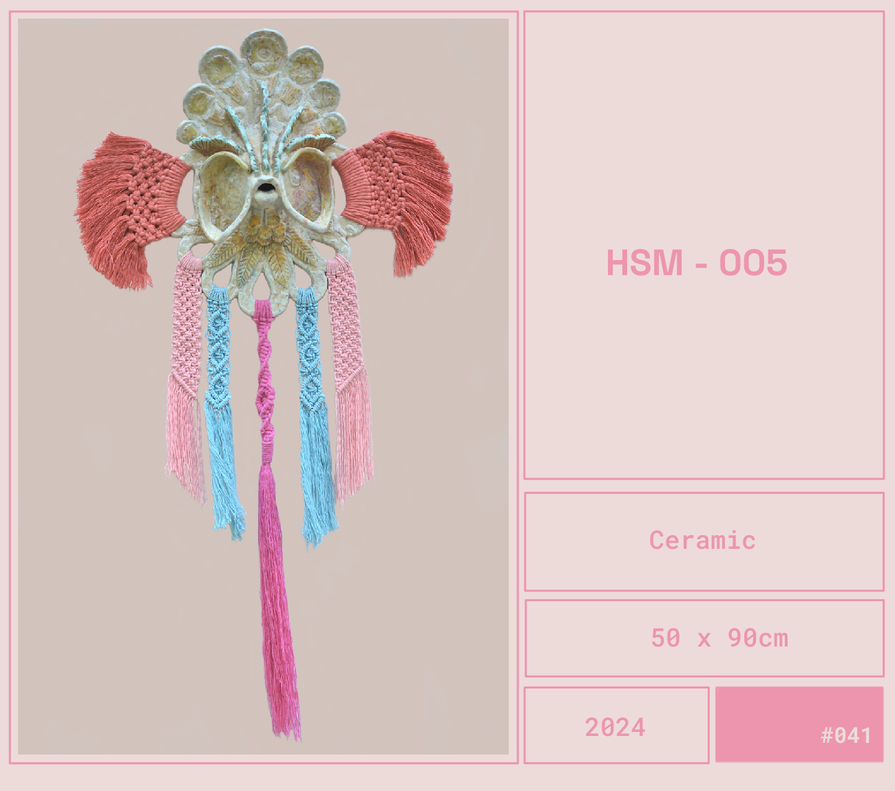 Un atrapasueños cerámico de tamaño 50 x 90 cm con detalles en tonos pastel como rosa, azul y amarillo, con un diseño elaborado que incluye plumas y cordones tejidos.