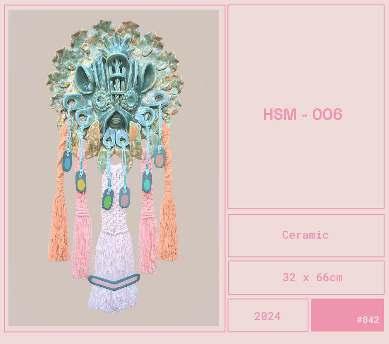 Arte cerámica con diseño de máscara tribal con detalles en azul y adornos de hilos rosados y verdes, medidor 32x66cm.