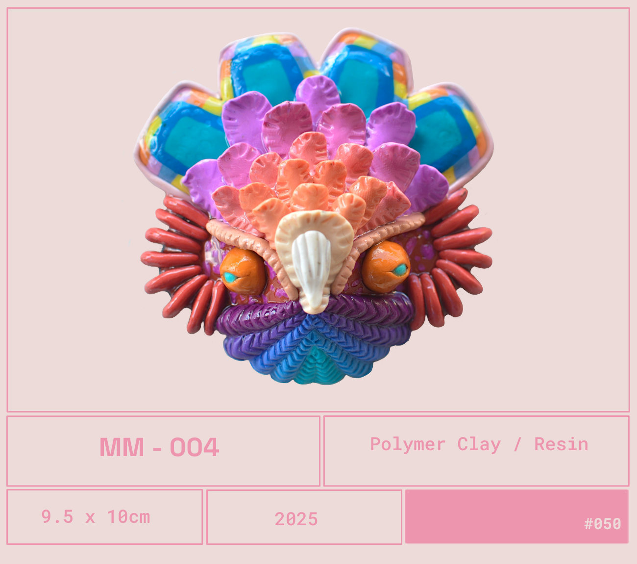 Escultura de arcilla polimérica que representa una cara colorida y abstracta con múltiples detalles en tonos vivos, sobre un fondo rosa claro.