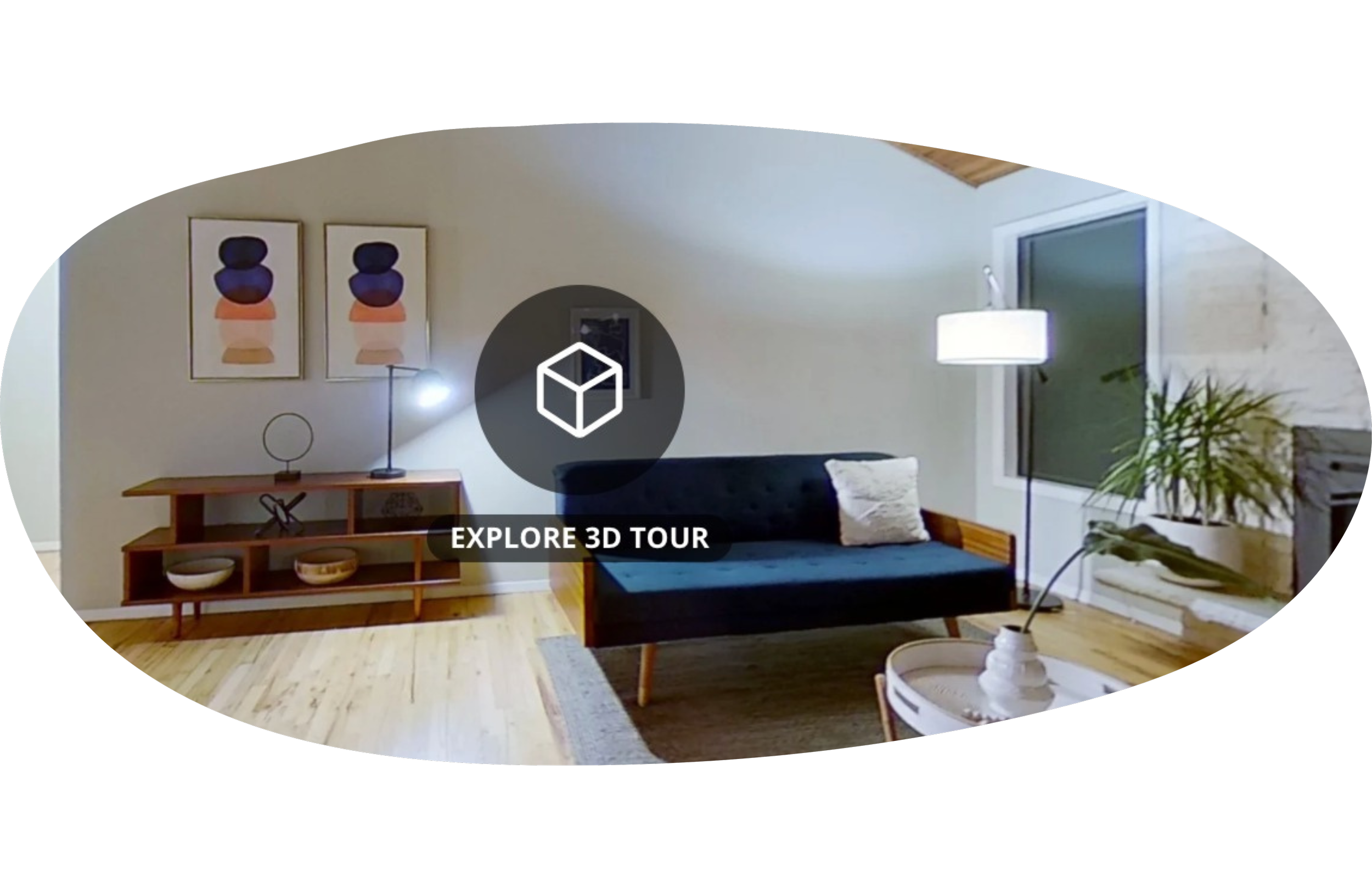Living room with a black sofa, white pillow, wooden console table, decorative art, and houseplant near a large window.