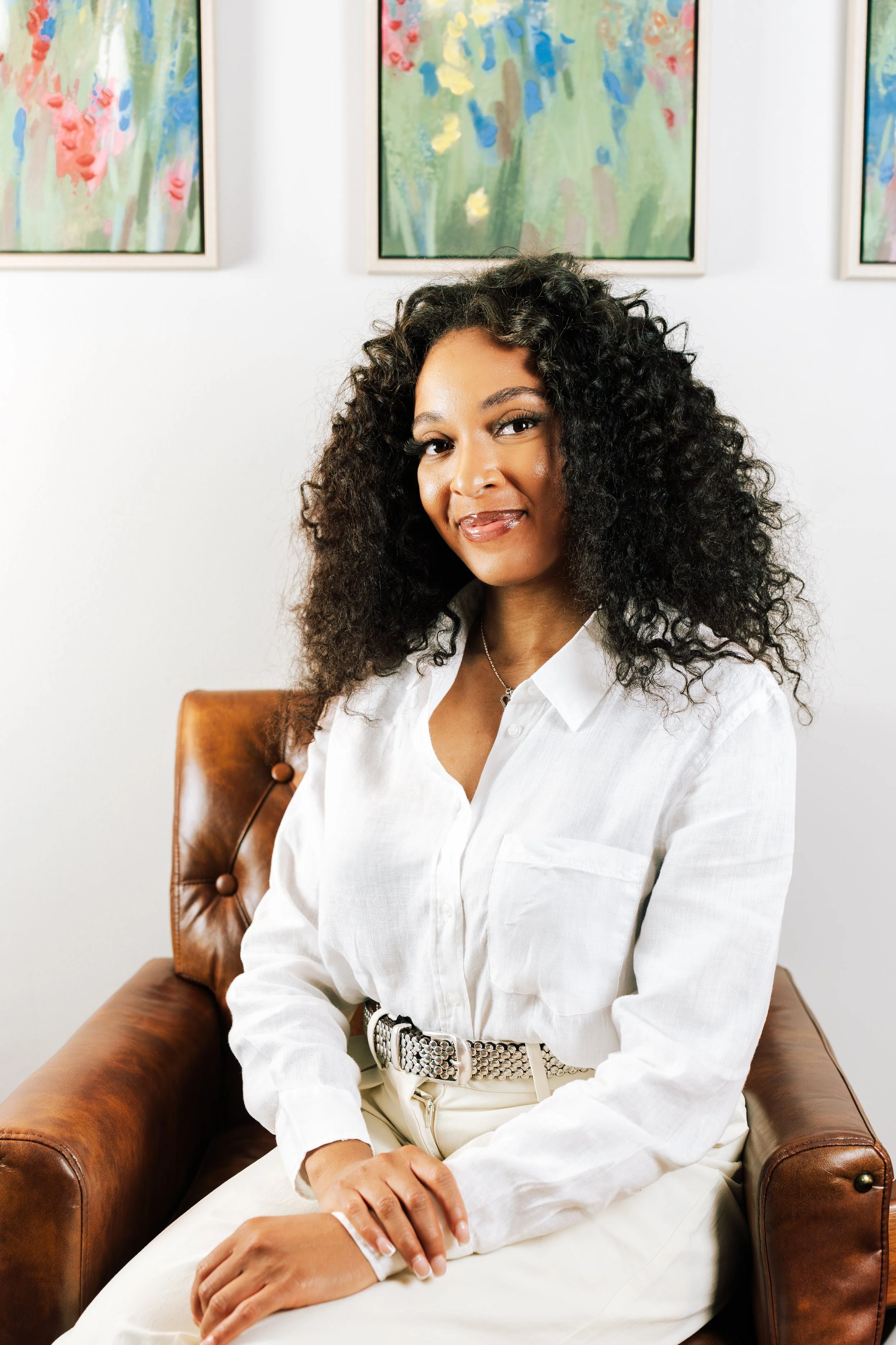 Black female therapist wearing a white shirt smiles at camera