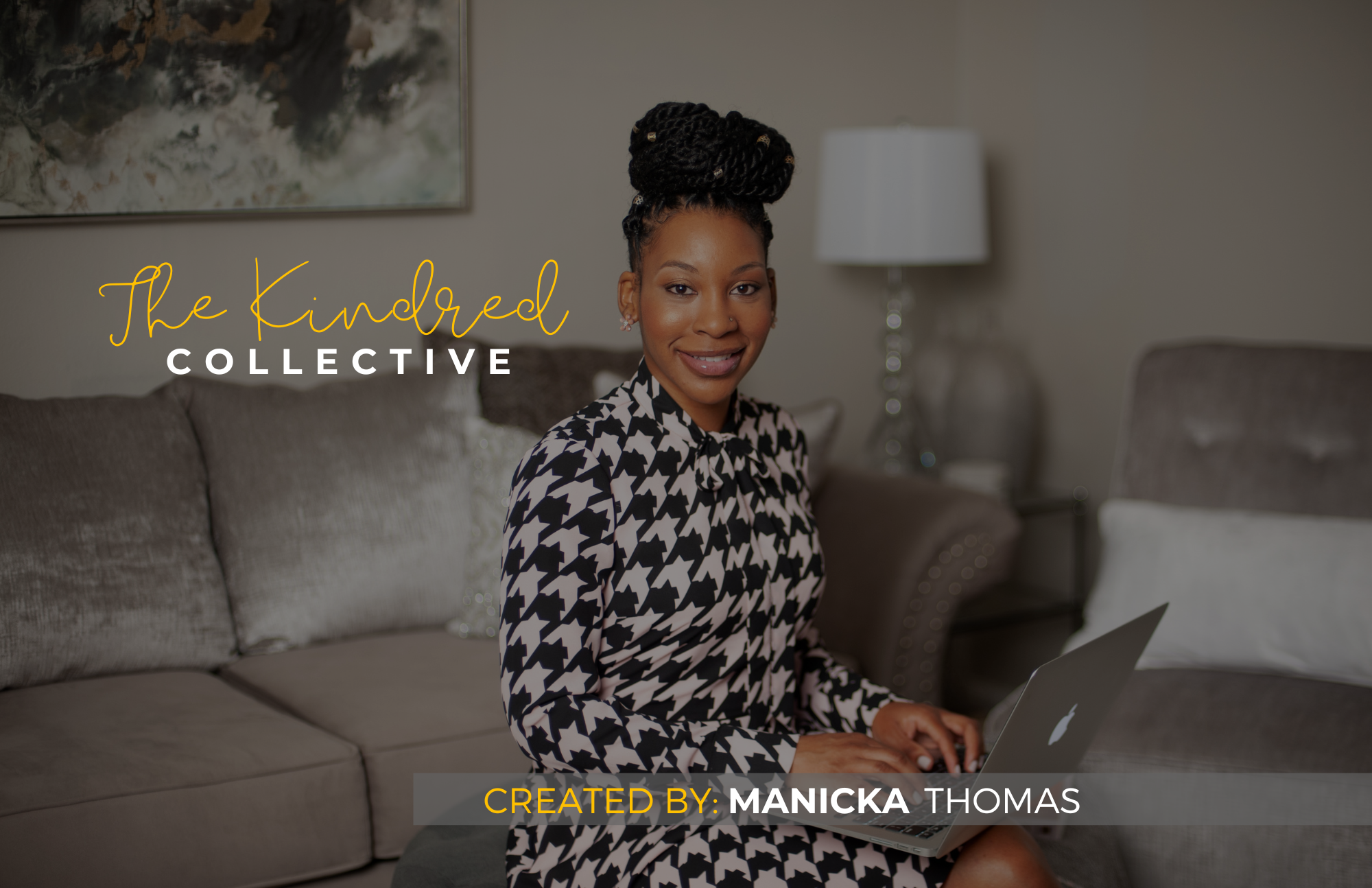 A woman sitting on a beige sofa, smiling, holding a laptop, in a cozy living room with a painting and a lamp in the background.