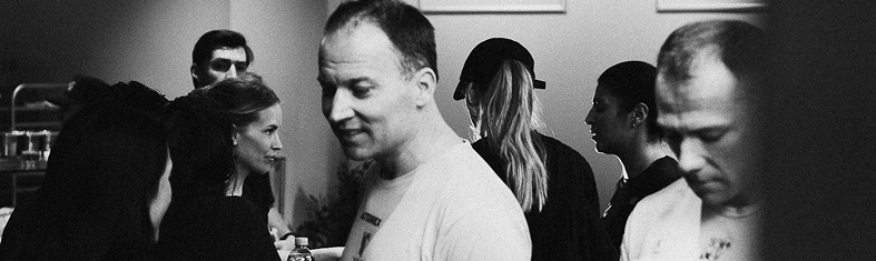 Grupp människor i ett rum, några ser precis ut att prata eller lyssna, svartvitt foto.