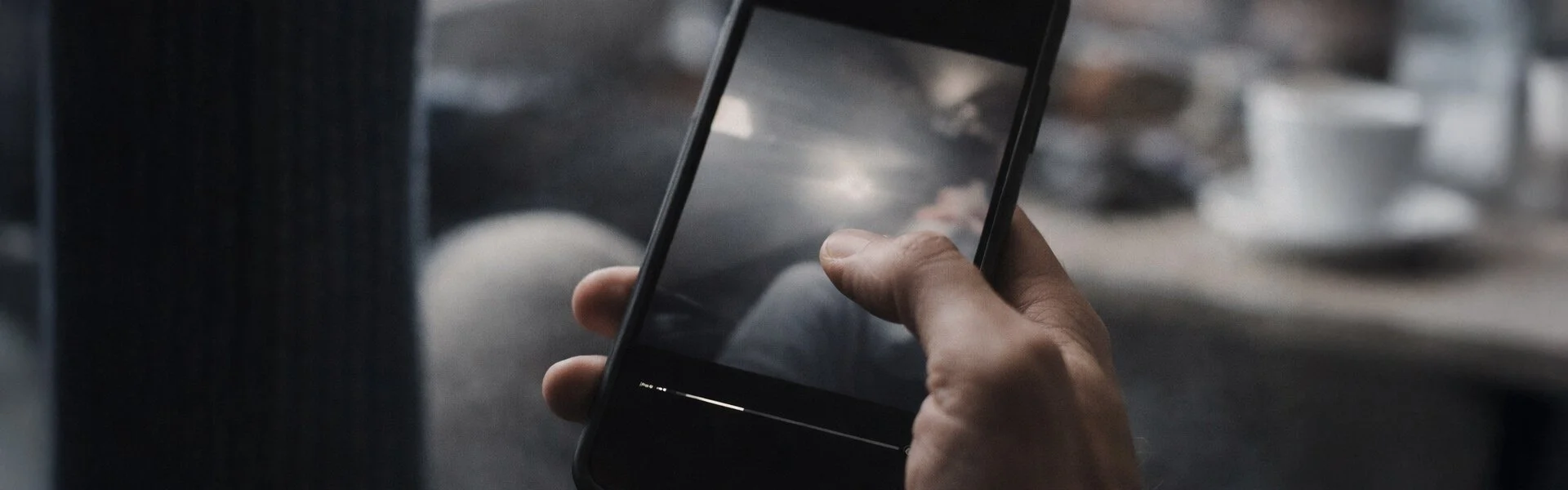 Hand holding a phone mid-playback, focusing on a small moment that carries feeling and meaning.