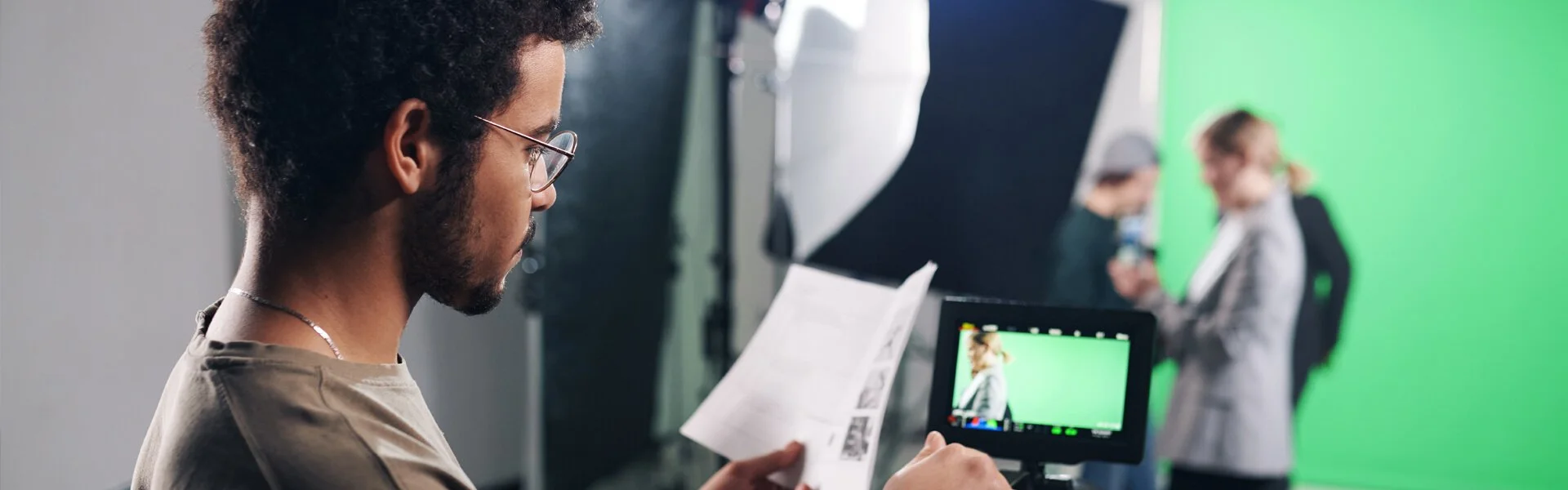 Crew member reviewing notes while filming a documentary-style brand interview on set.