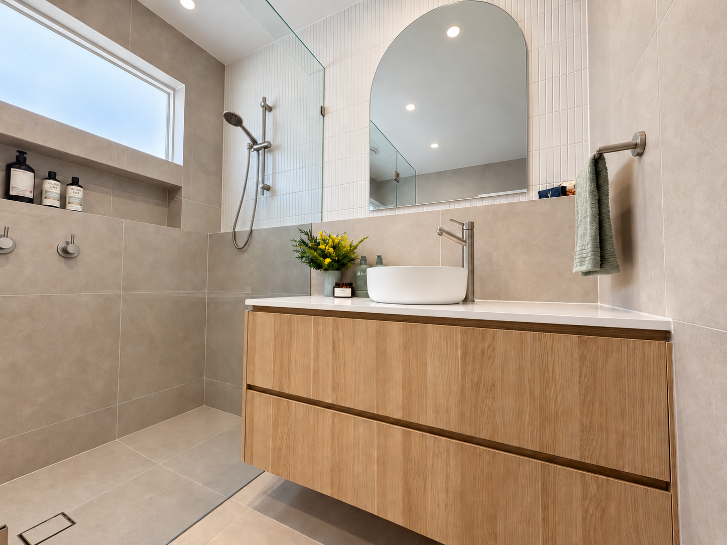 Mungari bathroom with floating oak vanity, vessel basin, arched mirror and walk-in shower with shower niche
