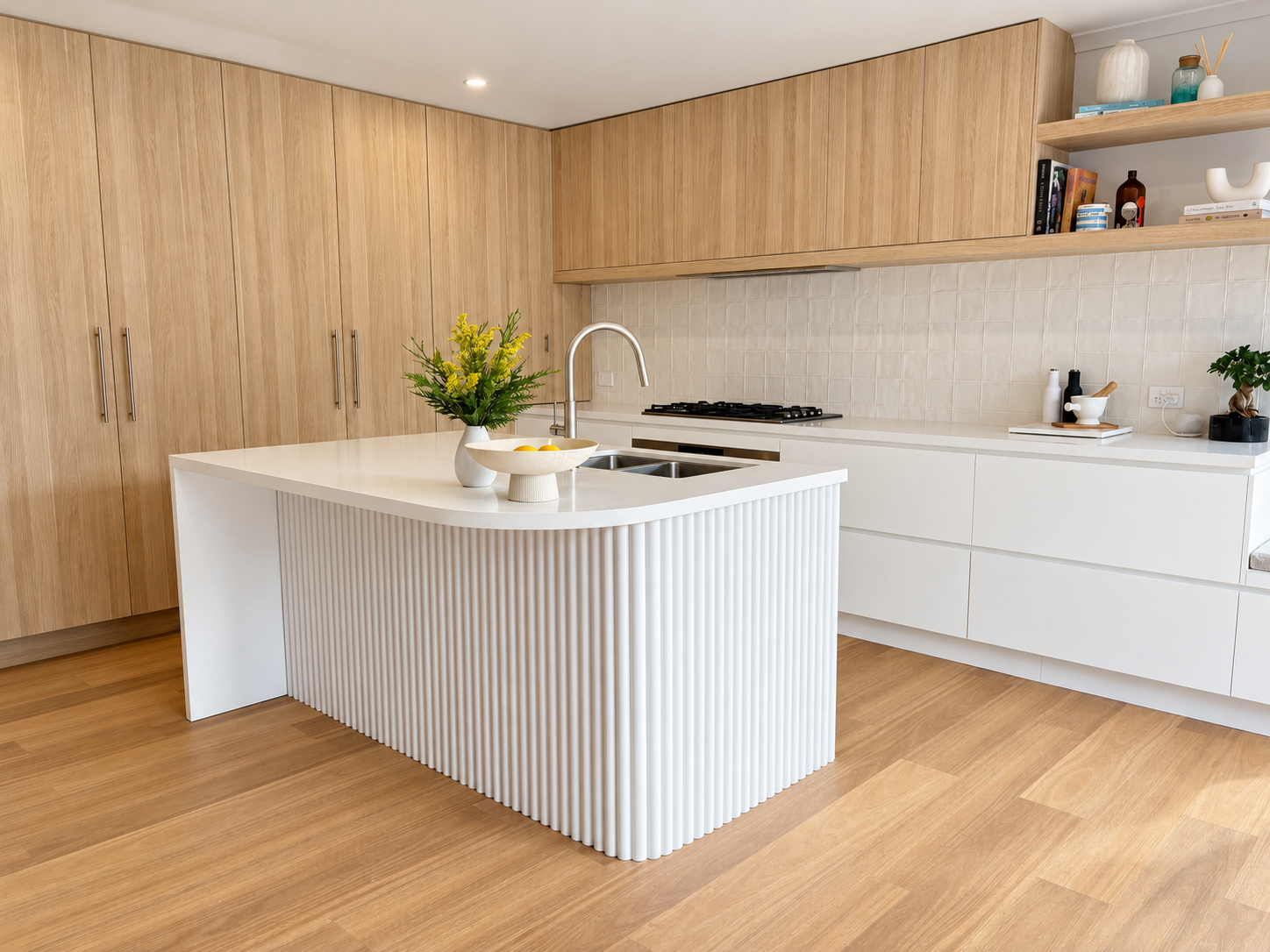 Mungari kitchen with white fluted island, oak overhead cabinets and floating shelves on light timber floors