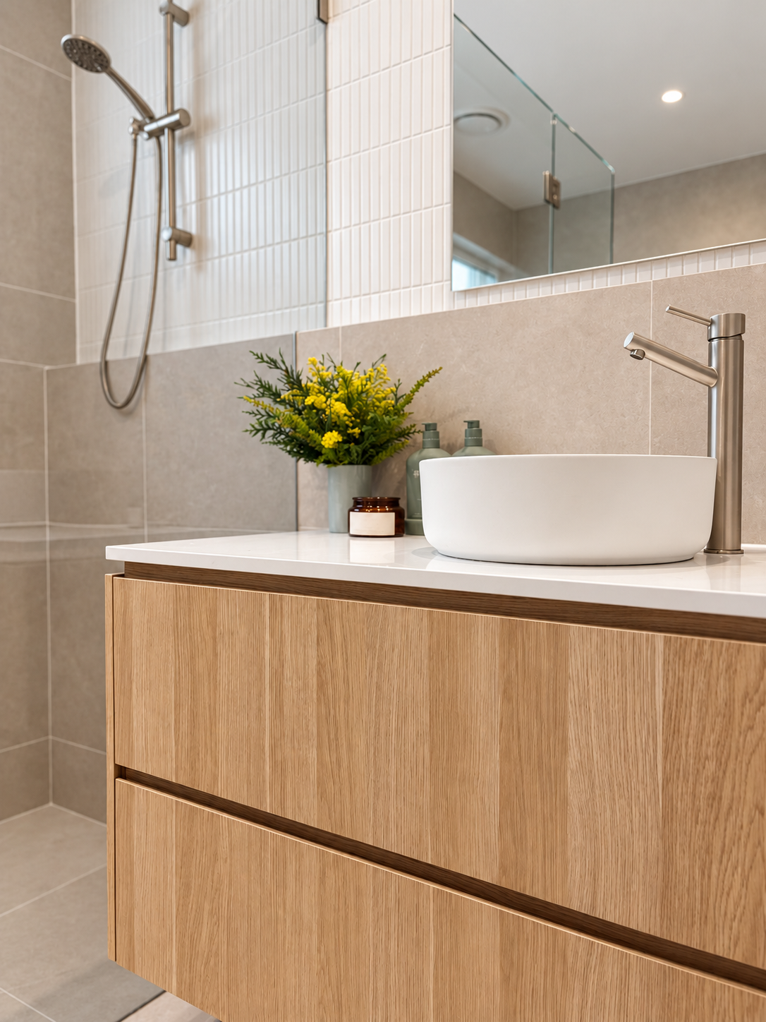 Close-up of the Mungari vanity: oak drawers, white vessel basin, brushed nickel tapware and vertical white wall tiles