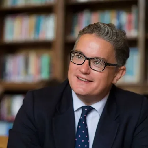 Image of Tom Rogerson, head at Cottesmore school. Tom is wearing glasses and looking away from the camera.