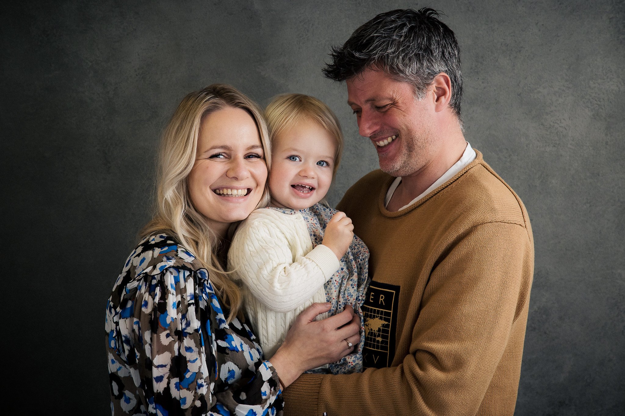 Glad familie poserer med fotograf i aalborg