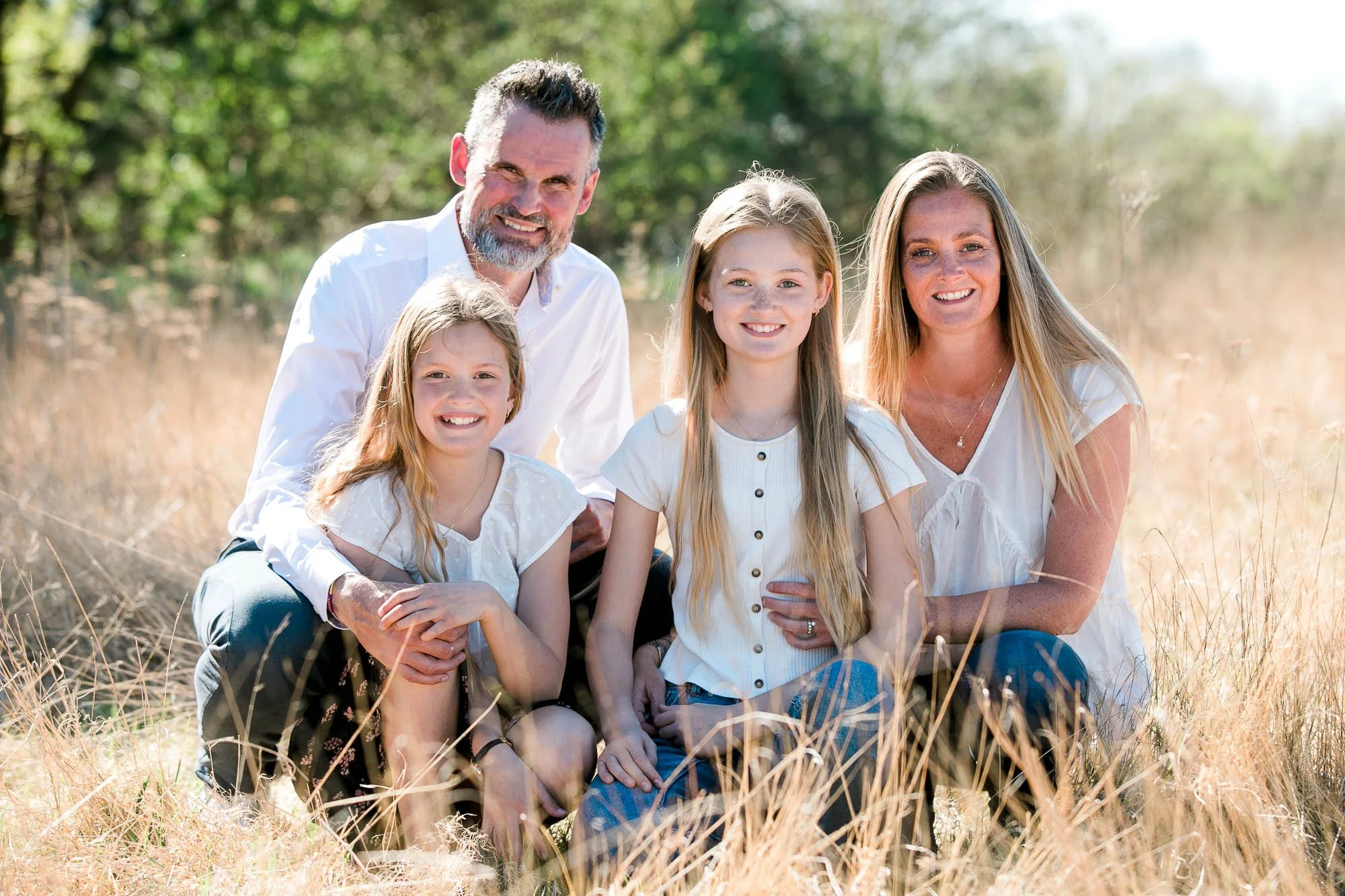 Location fotografering i Nordjylland: En familie poserer foran et smukt landskab.