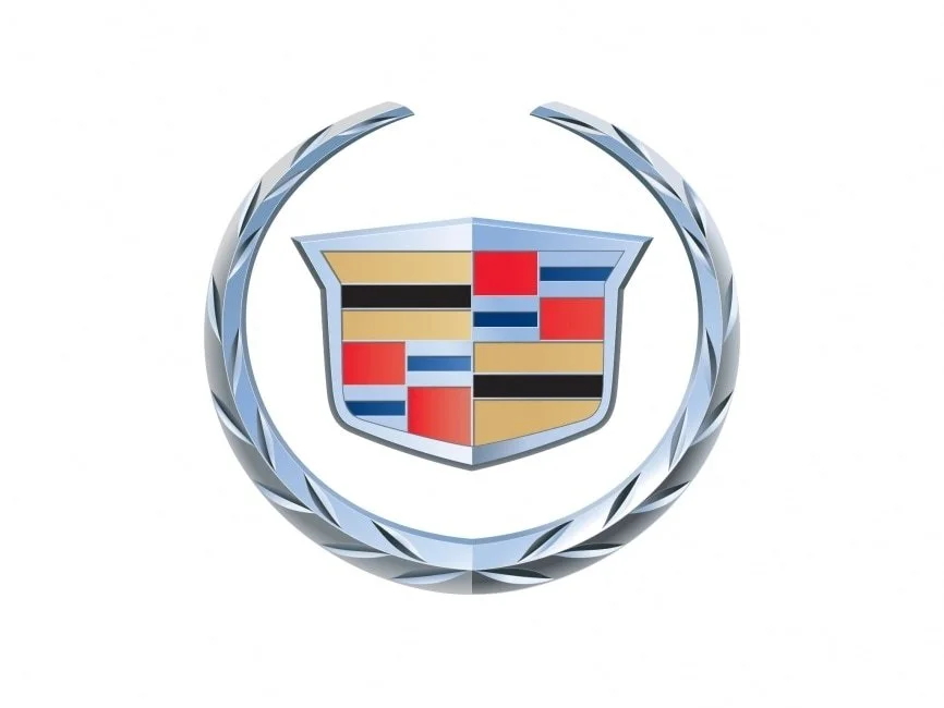 Logo Cadillac con scudo multicolore e corona d'alloro, sfondo bianco.