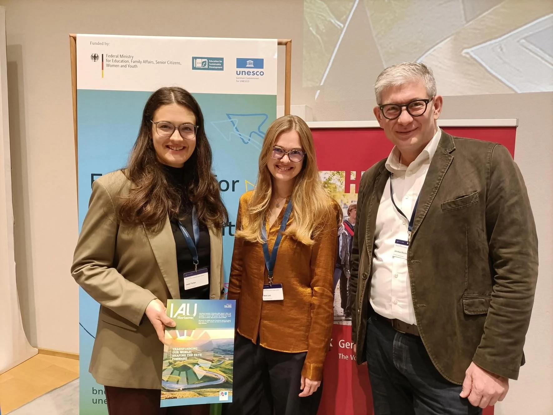 IAU and HRK colleagues (Maike Land and Jacobus Bracker), Isabel Toman (IAU) holding a copy of IAU Horizons
