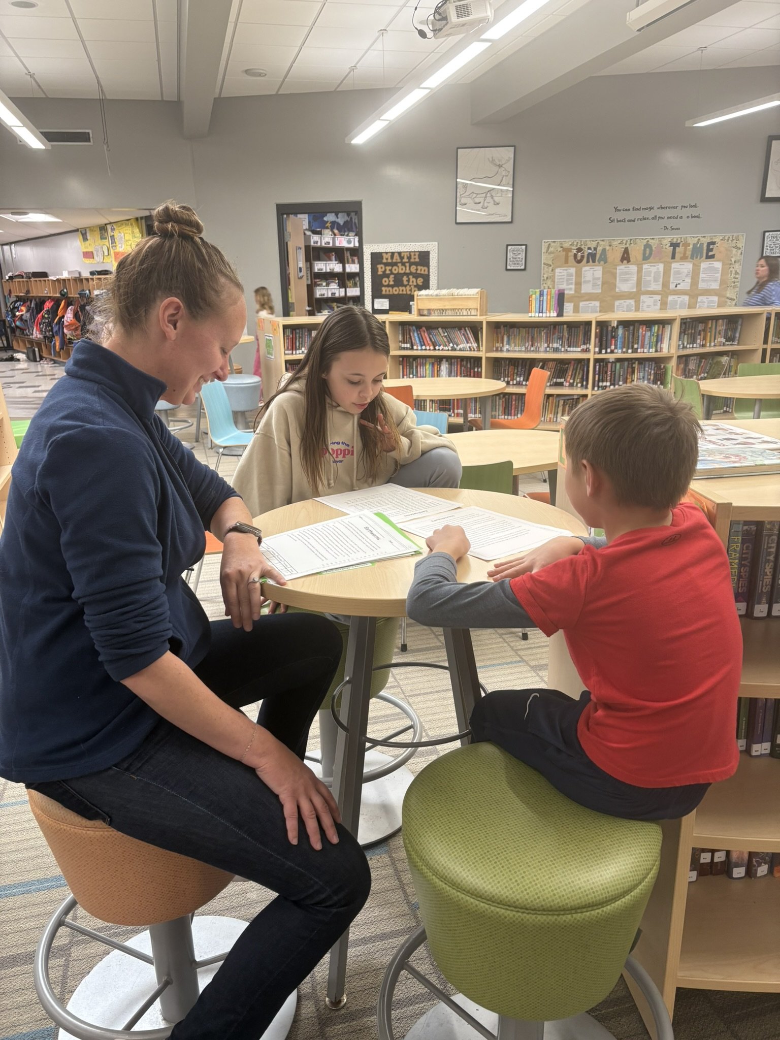 two students reading with a volunteer