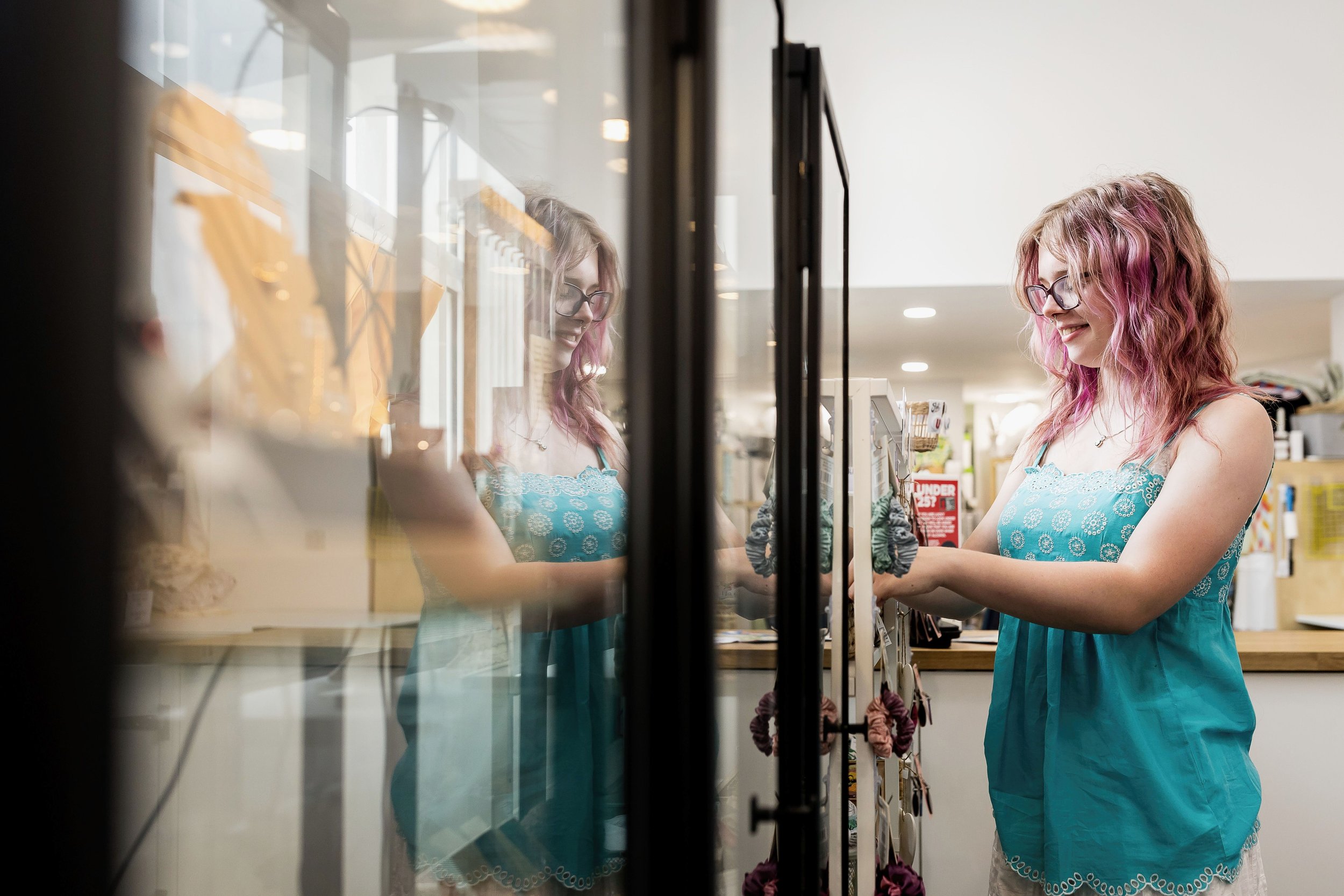 reflected in a glass door while arranging scrunchies