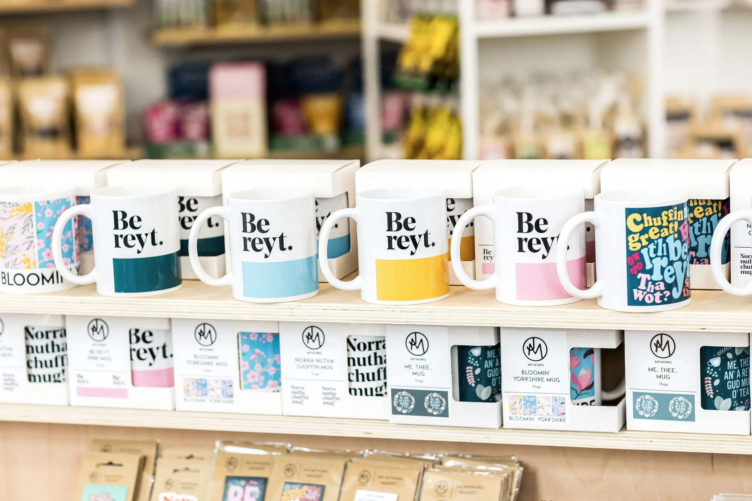 Row of "Be reyt" Yorkshire dialect mugs in teal, blue, yellow and pink