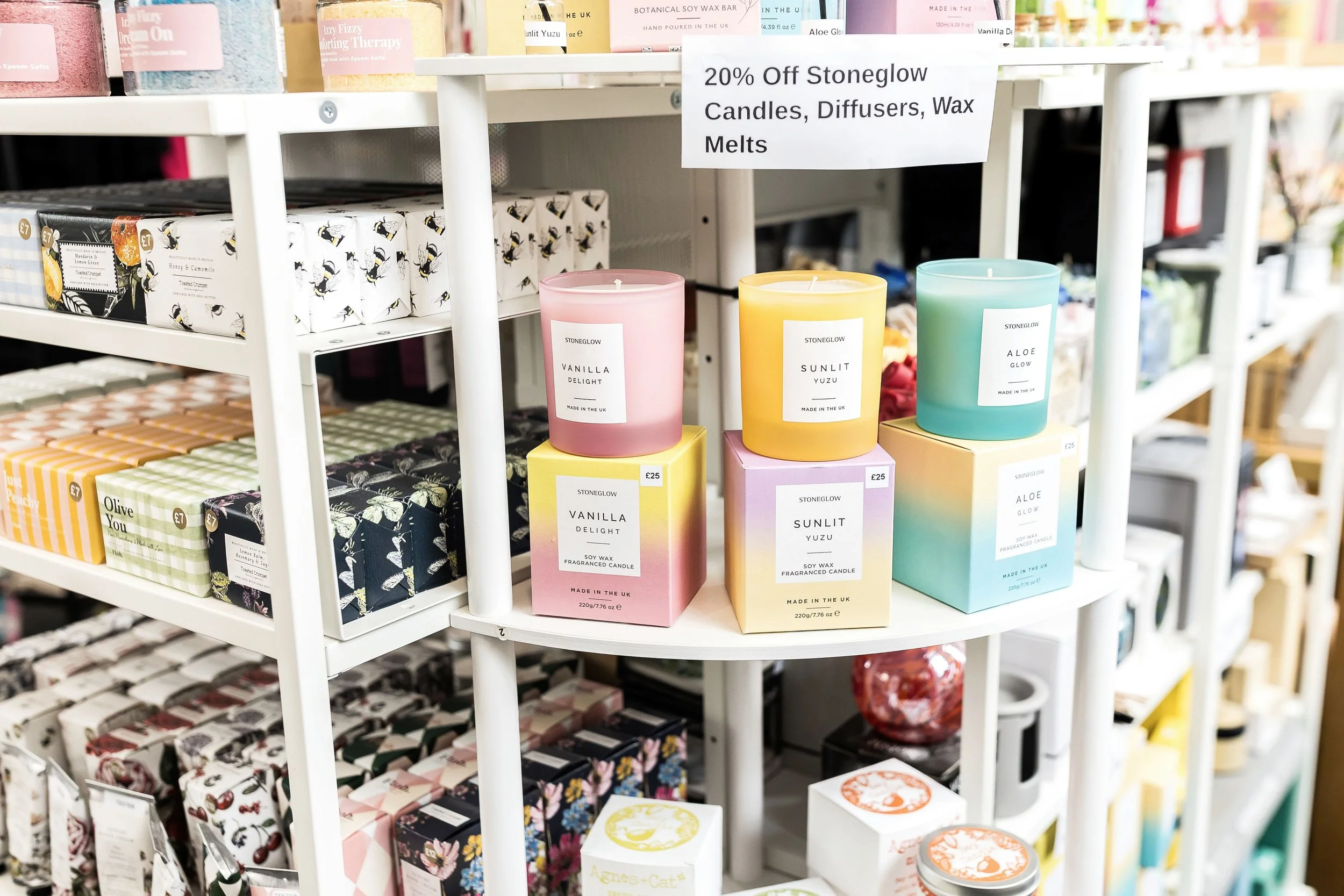 Pastel Stoneglow candles on a white corner shelf in an independent Brighouse shop