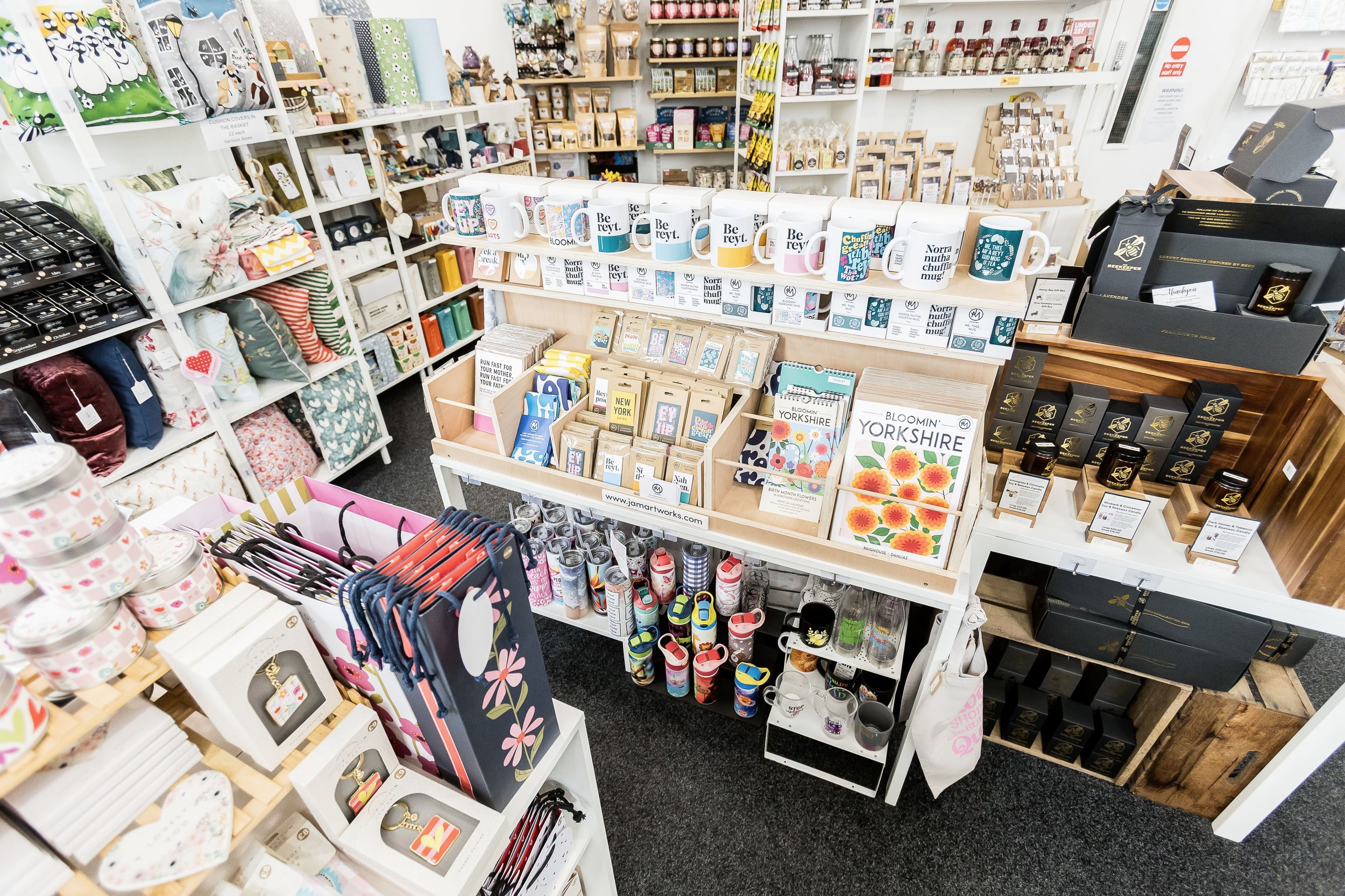 Wide view inside Simply Divine Things gift shop in Brighouse, with mugs, prints and candles on display