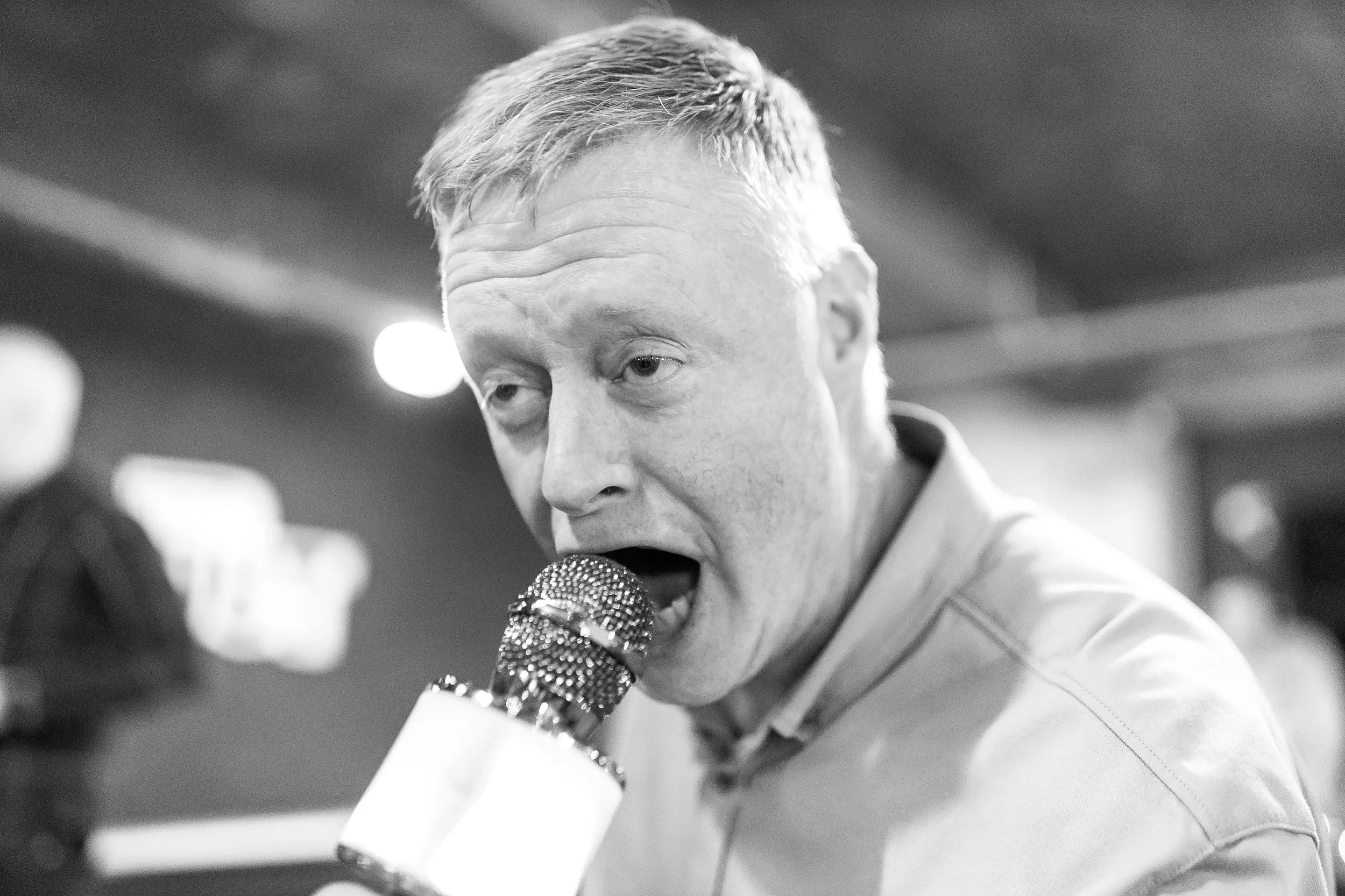 Phil singing with microphone at SAM Christmas party