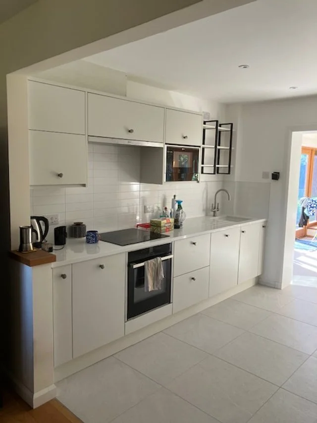 Modern kitchen with white countertop and cabinets. 