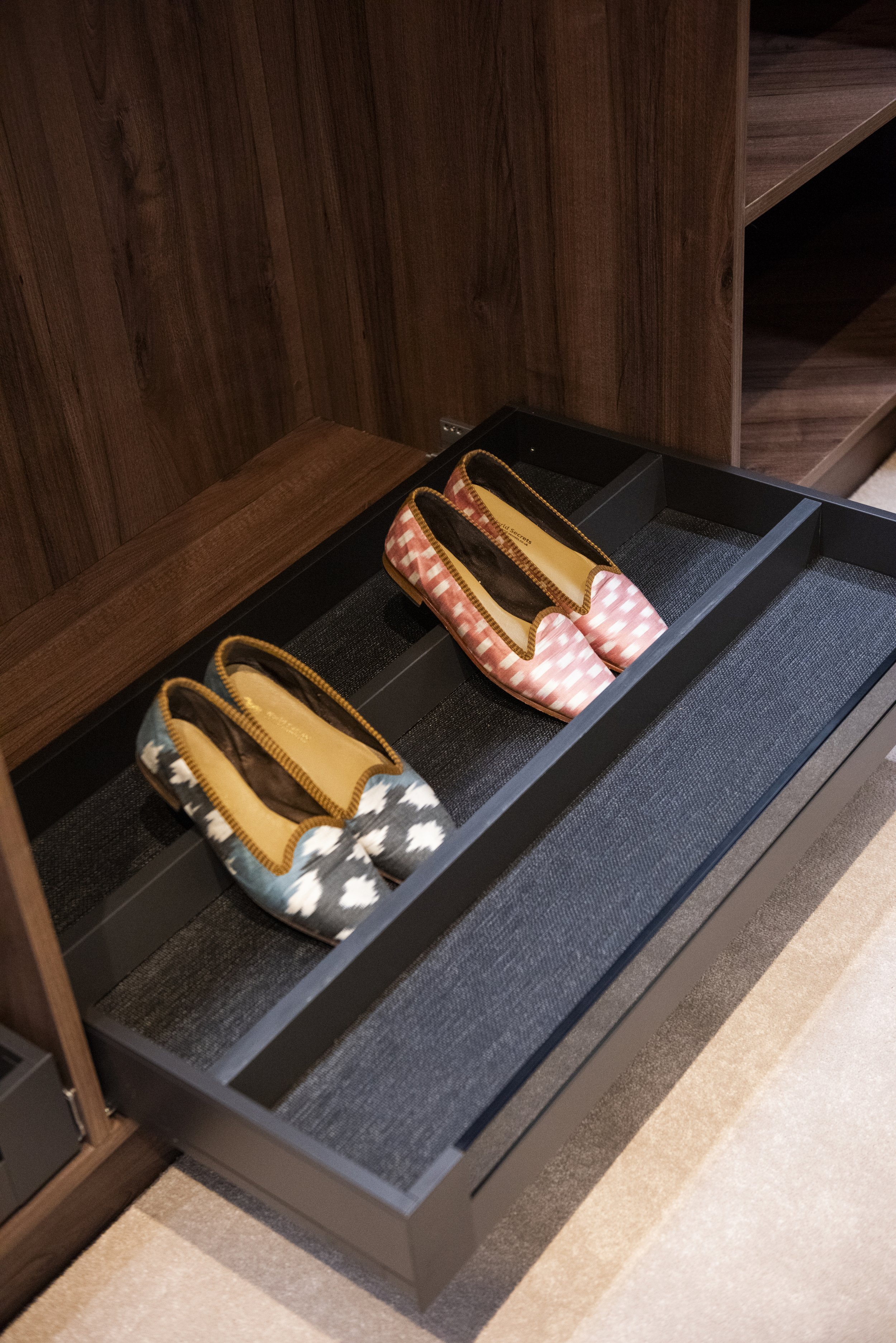 A open shoe rack with pairs of shoes placed on it.